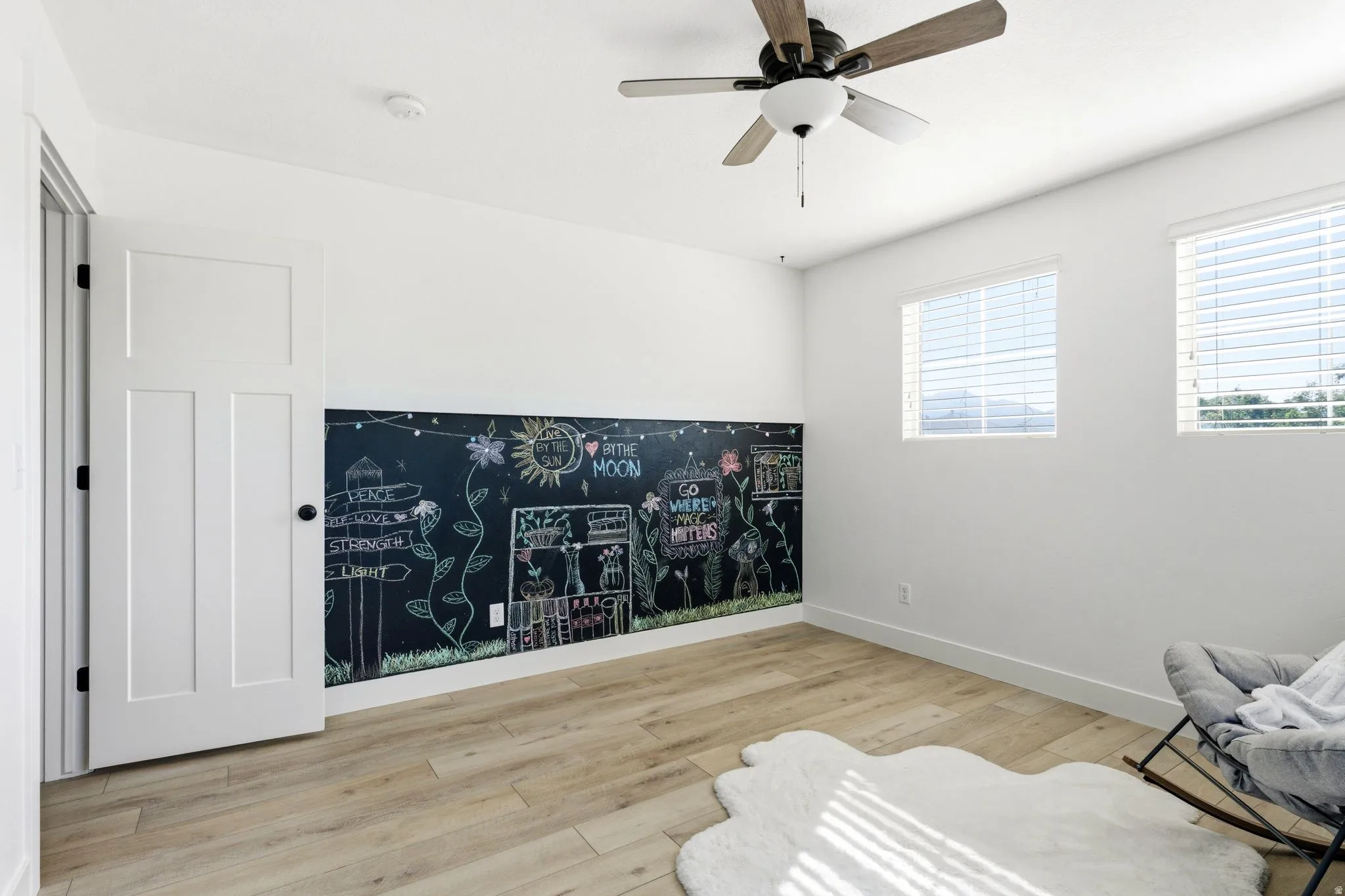 Chalkboard accent wall with light wood-finish flooring