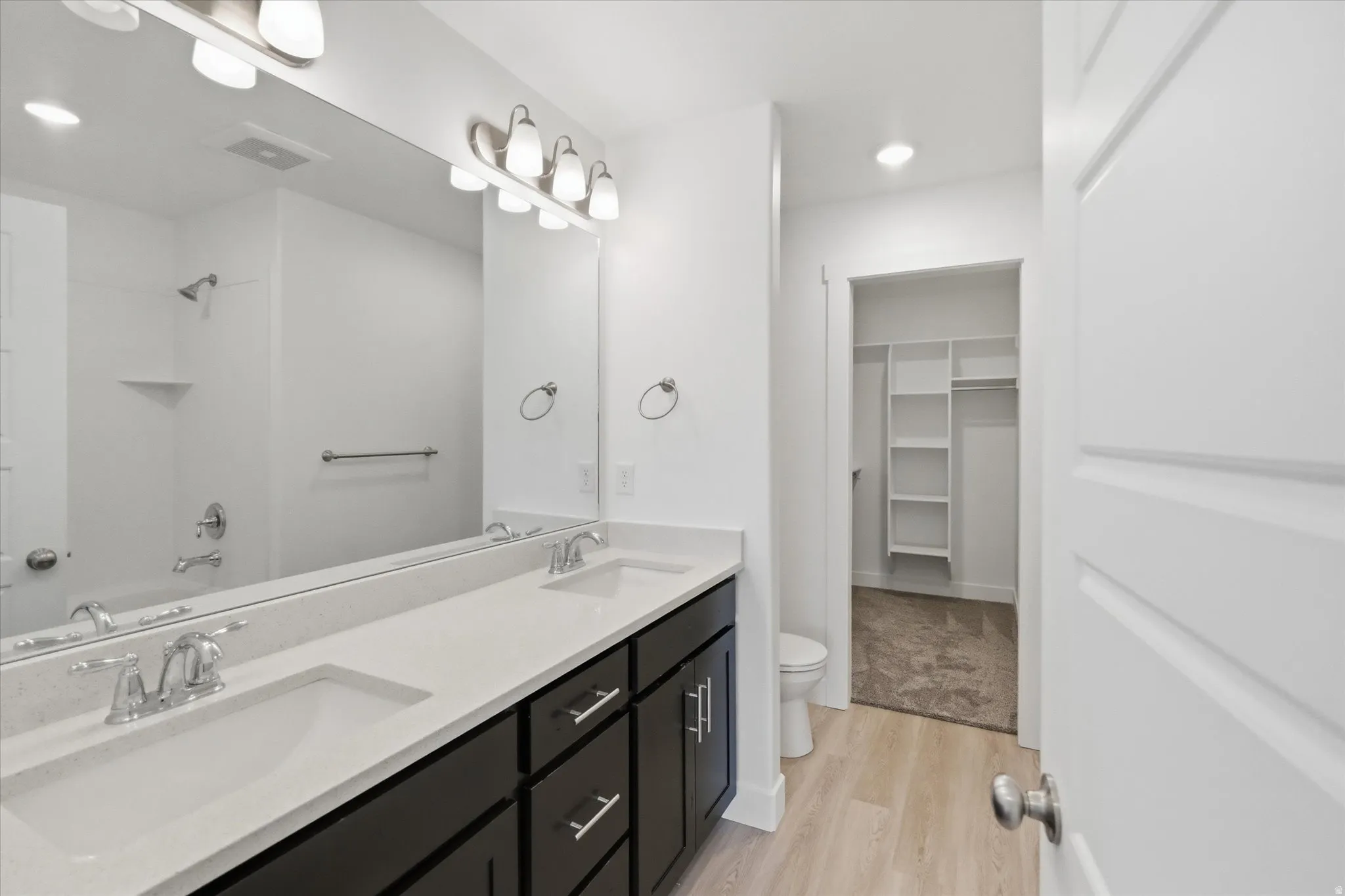 Double vanity with undermount sinks, chrome fixtures, and a light-toned countertop
