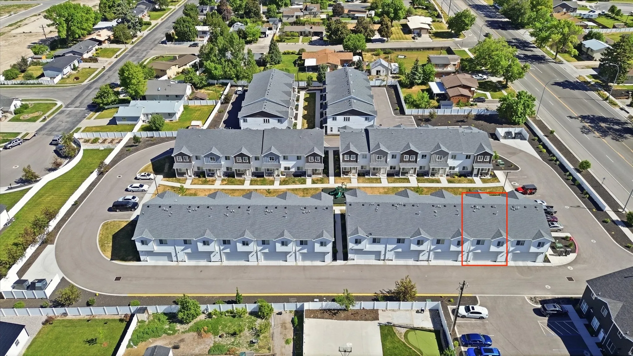 Contemporary townhome development featuring multiple units with individual garages and a shared paved driveway