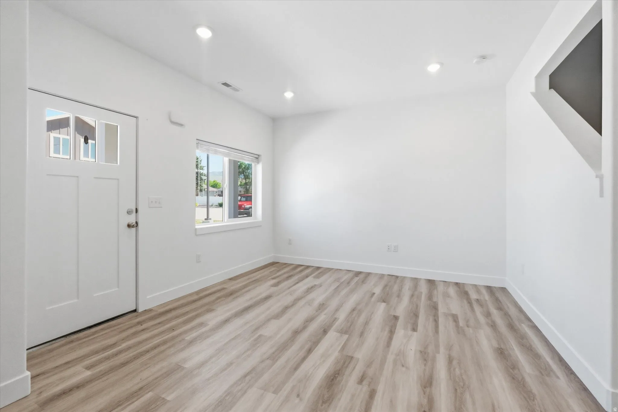 Open concept living space featuring wood-finish flooring and recessed lighting