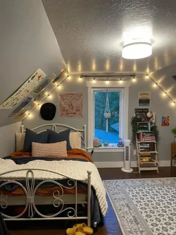 Bedroom featuring a window with natural light, sloped ceiling, overhead lighting fixture, and dark wood-finish flooring