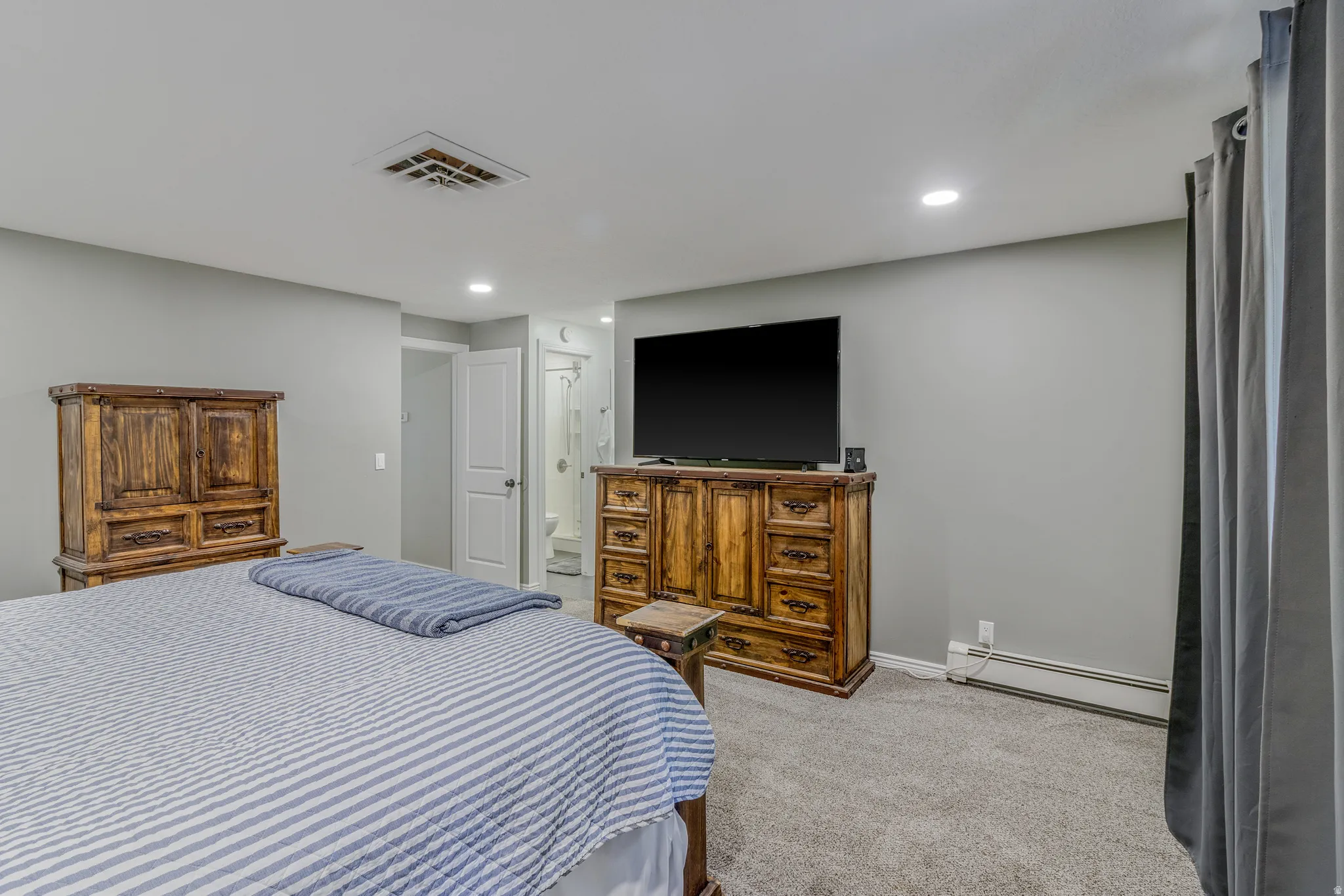 Carpeted bedroom with neutral gray walls and recessed lighting