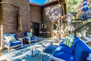 Spacious outdoor patio featuring brick exterior, a multi-level design, concrete steps, and a privacy wall