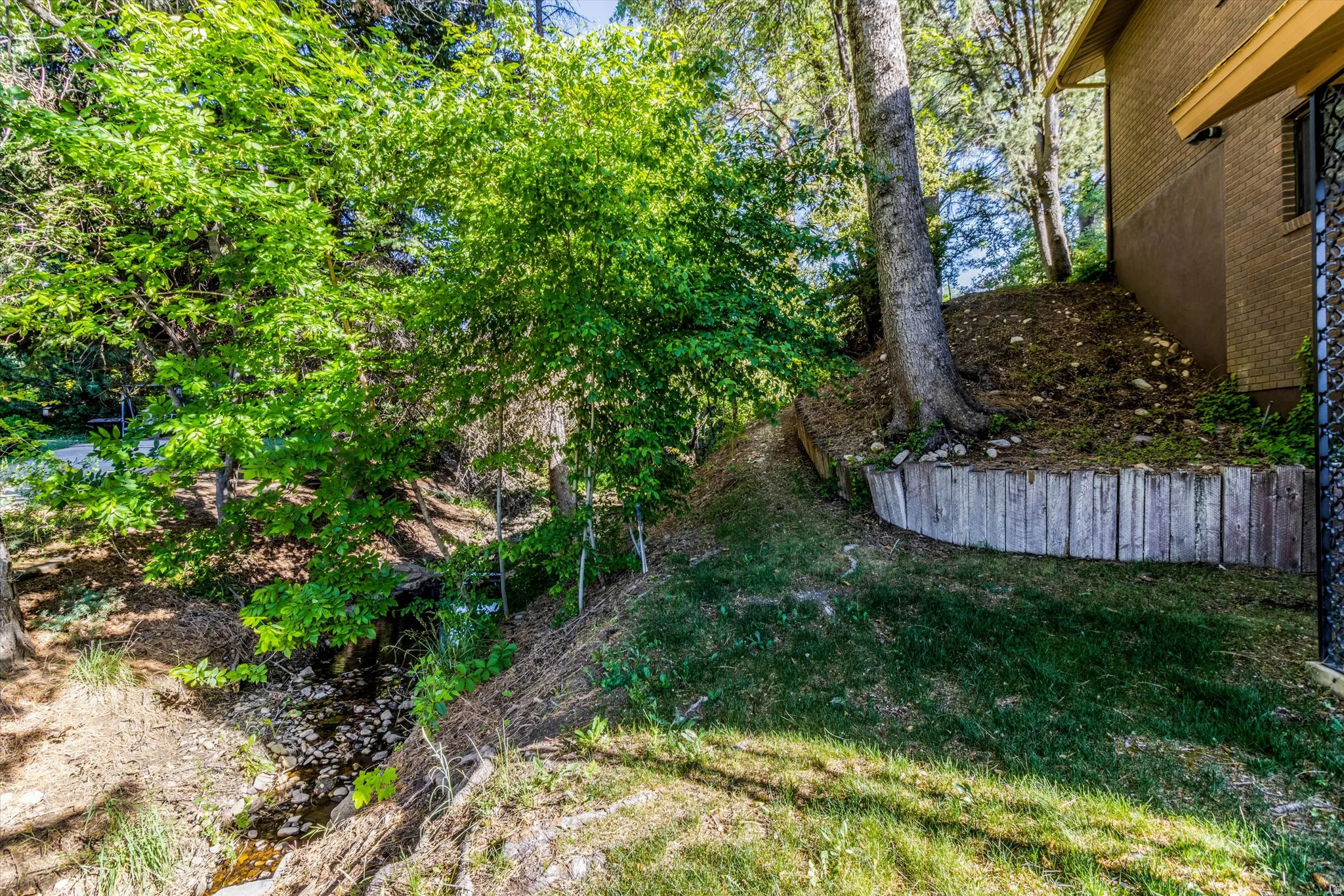 Wood retaining wall bordering a sloped grassy area