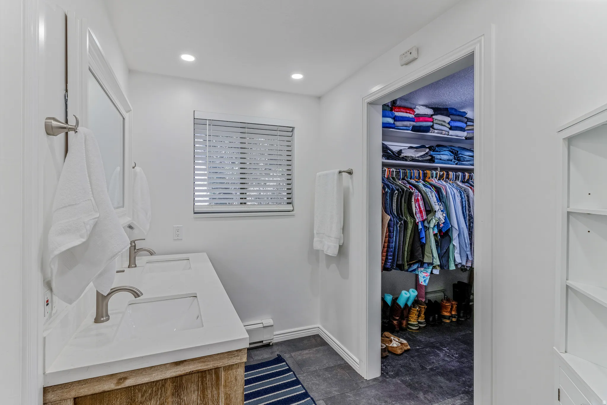 Bathroom featuring a double vanity with stone countertops, individual sinks, and brushed nickel fixtures