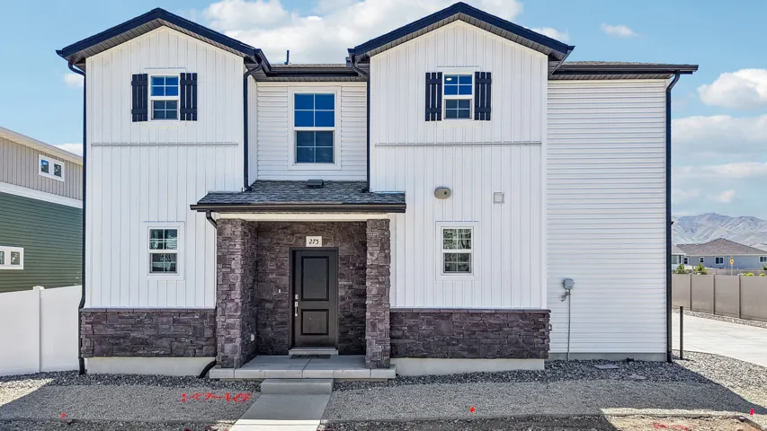 Contemporary exterior featuring a covered entry, dark stone veneer accents, white board and batten siding, white horizontal siding, and dark shutters