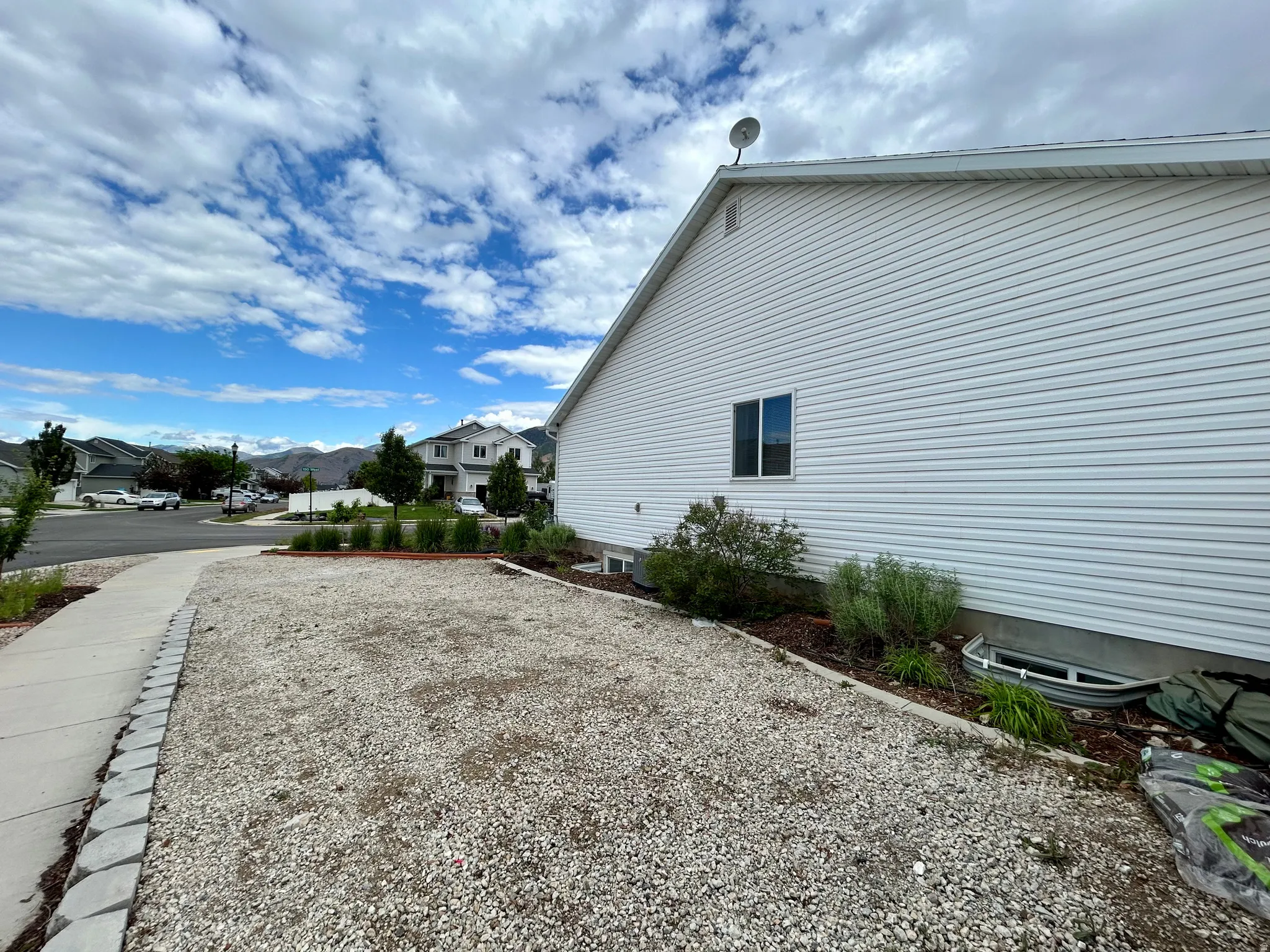 White vinyl siding exterior with a single window and a visible foundation