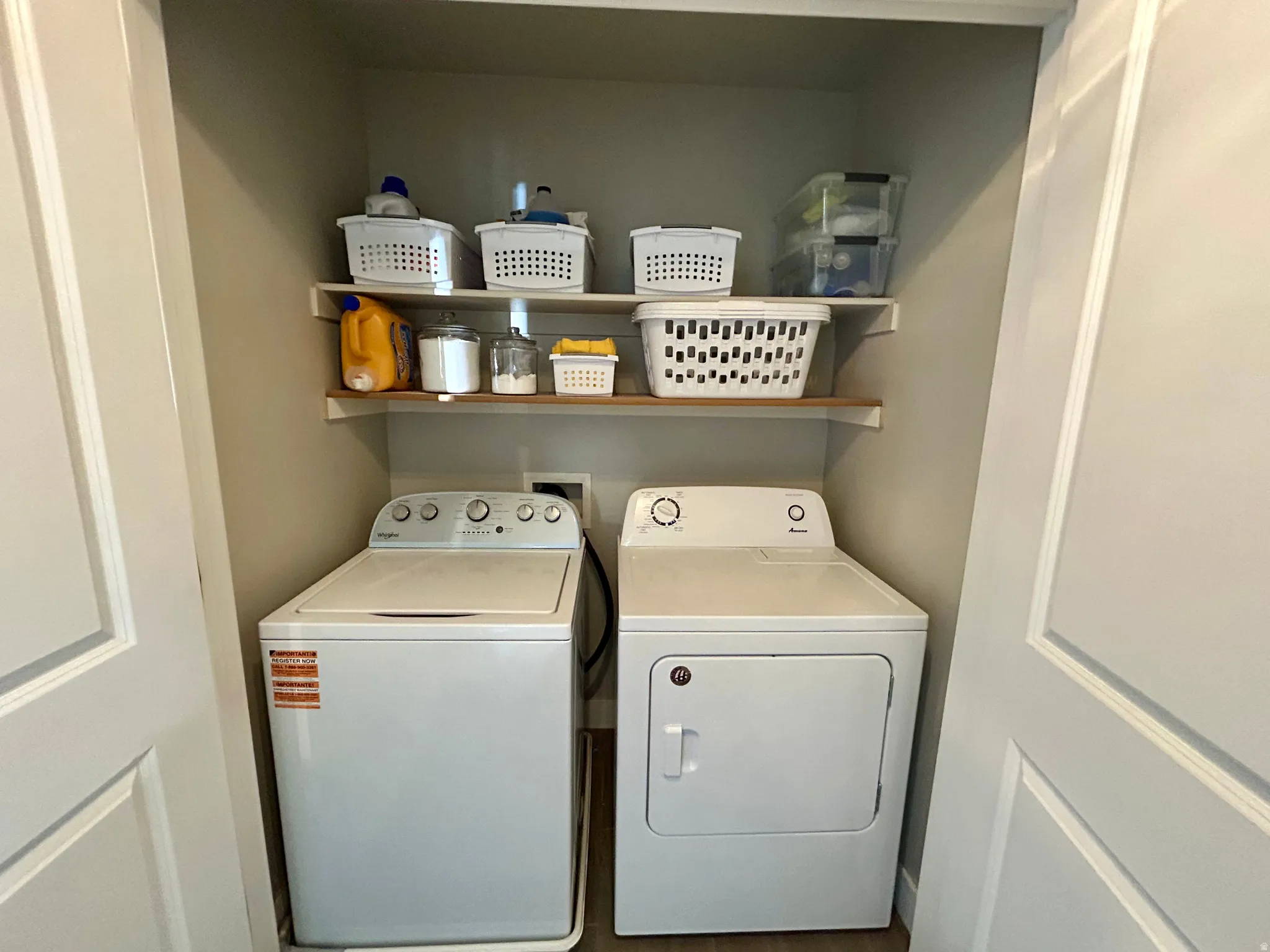 Dedicated laundry alcove featuring a top-load washing machine and front-load dryer
