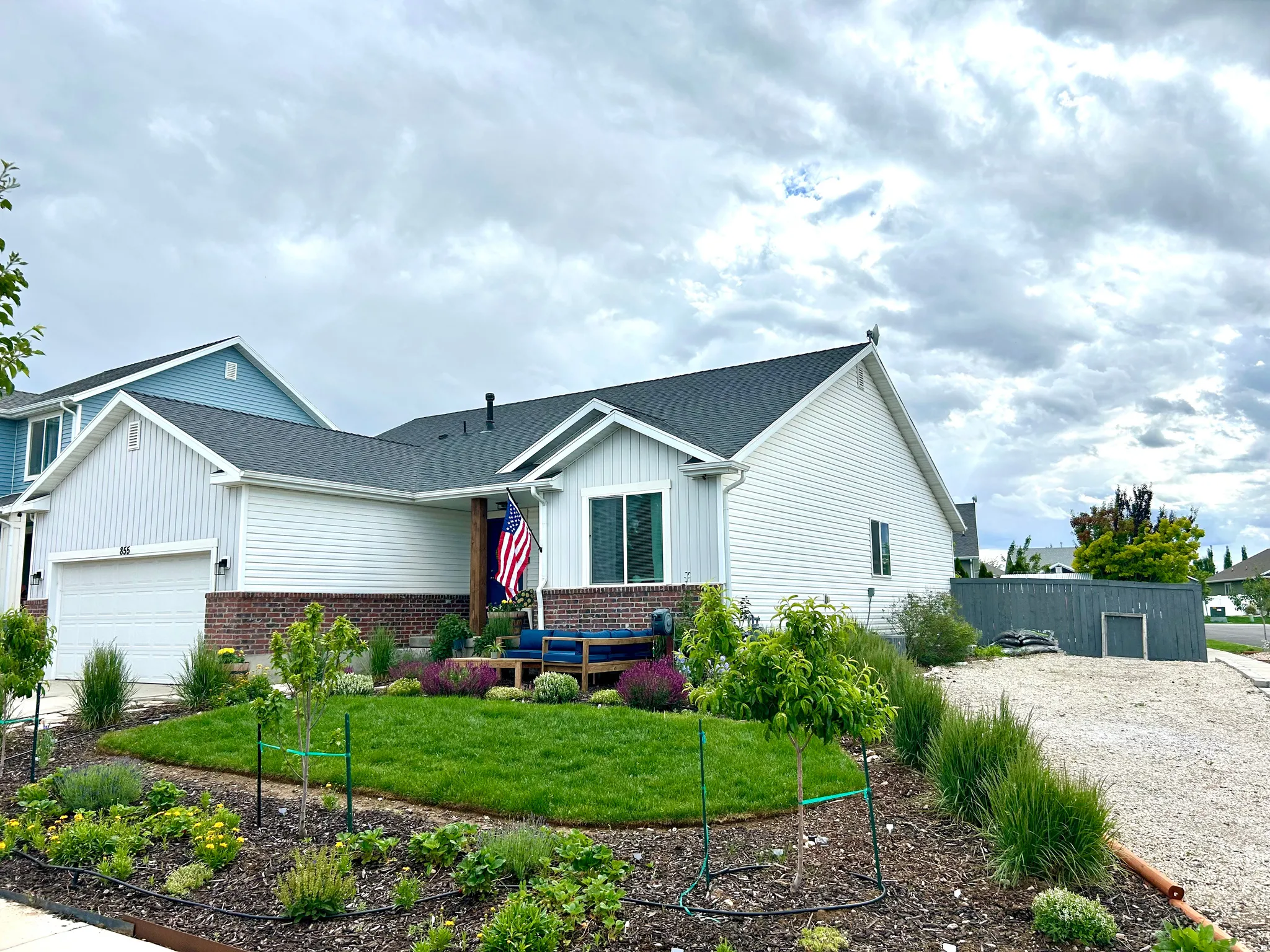 Single-story residence featuring white siding and a dark shingle roof