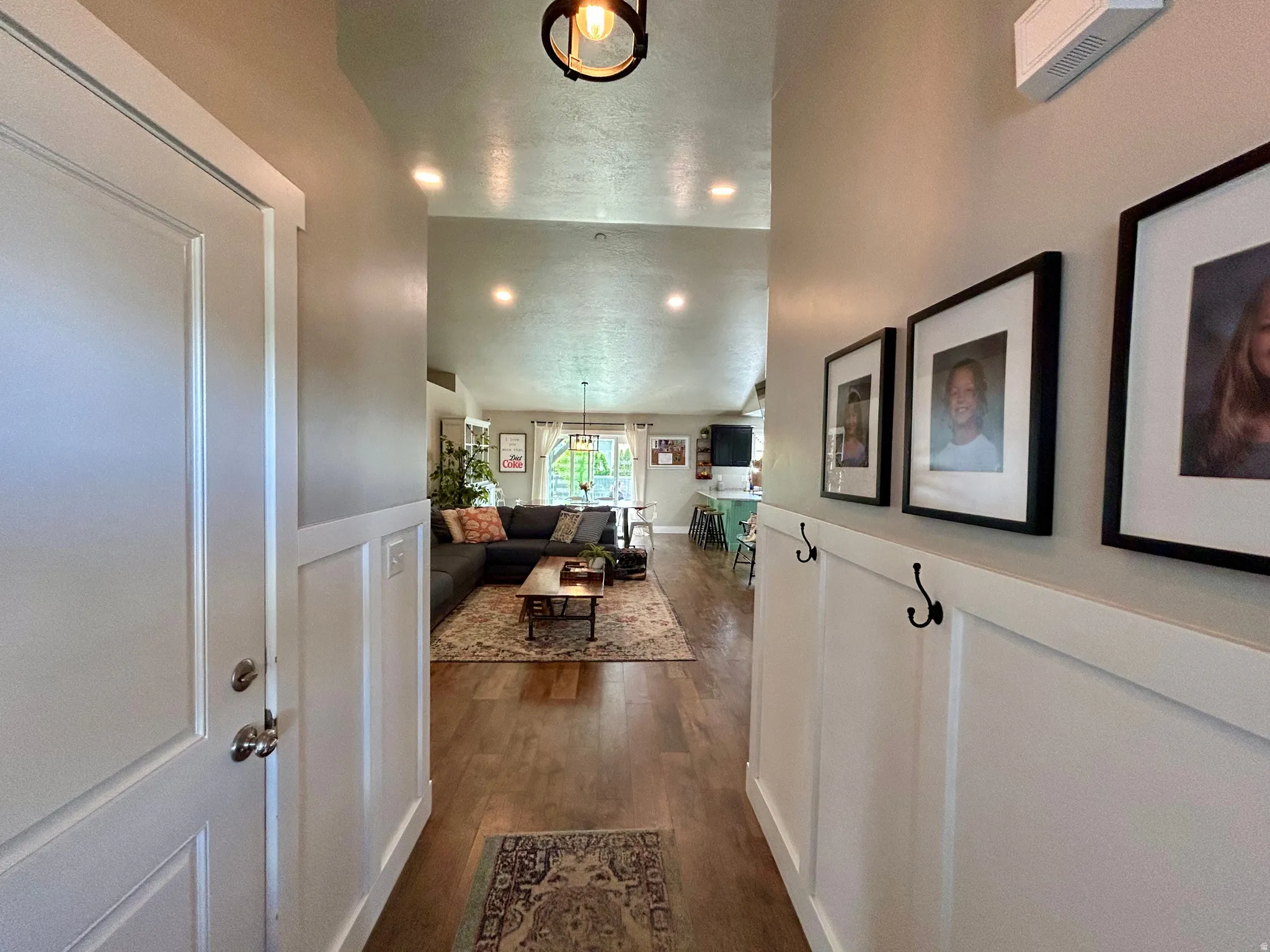Entryway featuring wainscoting with integrated hooks, wood-finish flooring, and recessed lighting