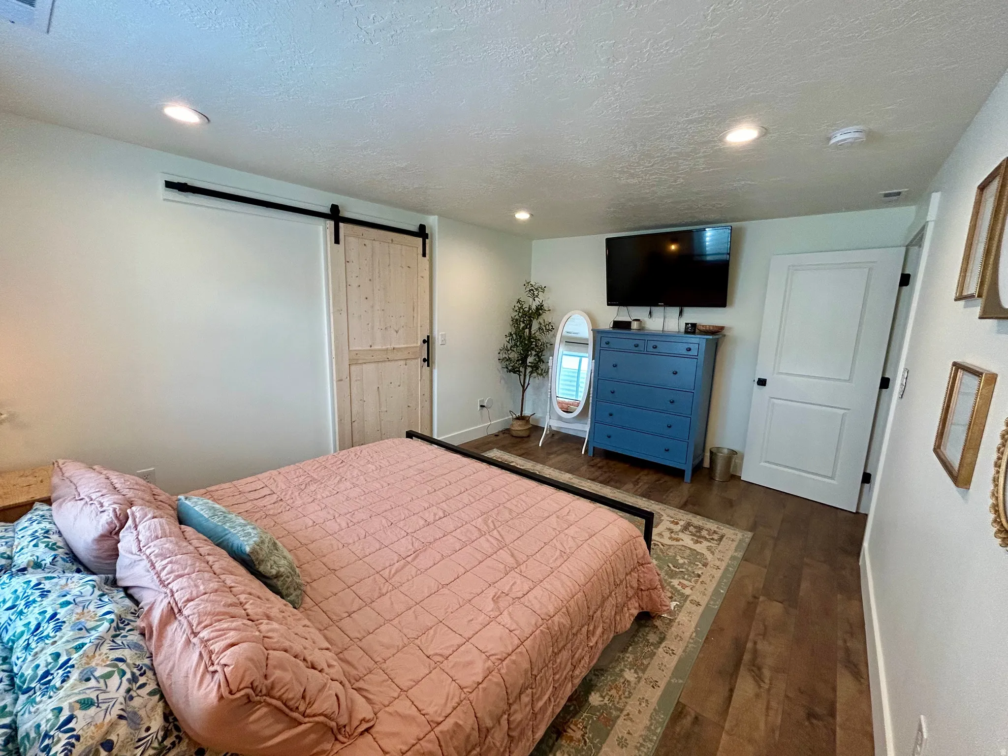 Interior room featuring wood-finish flooring, recessed lighting, and a modern barn door with black hardware