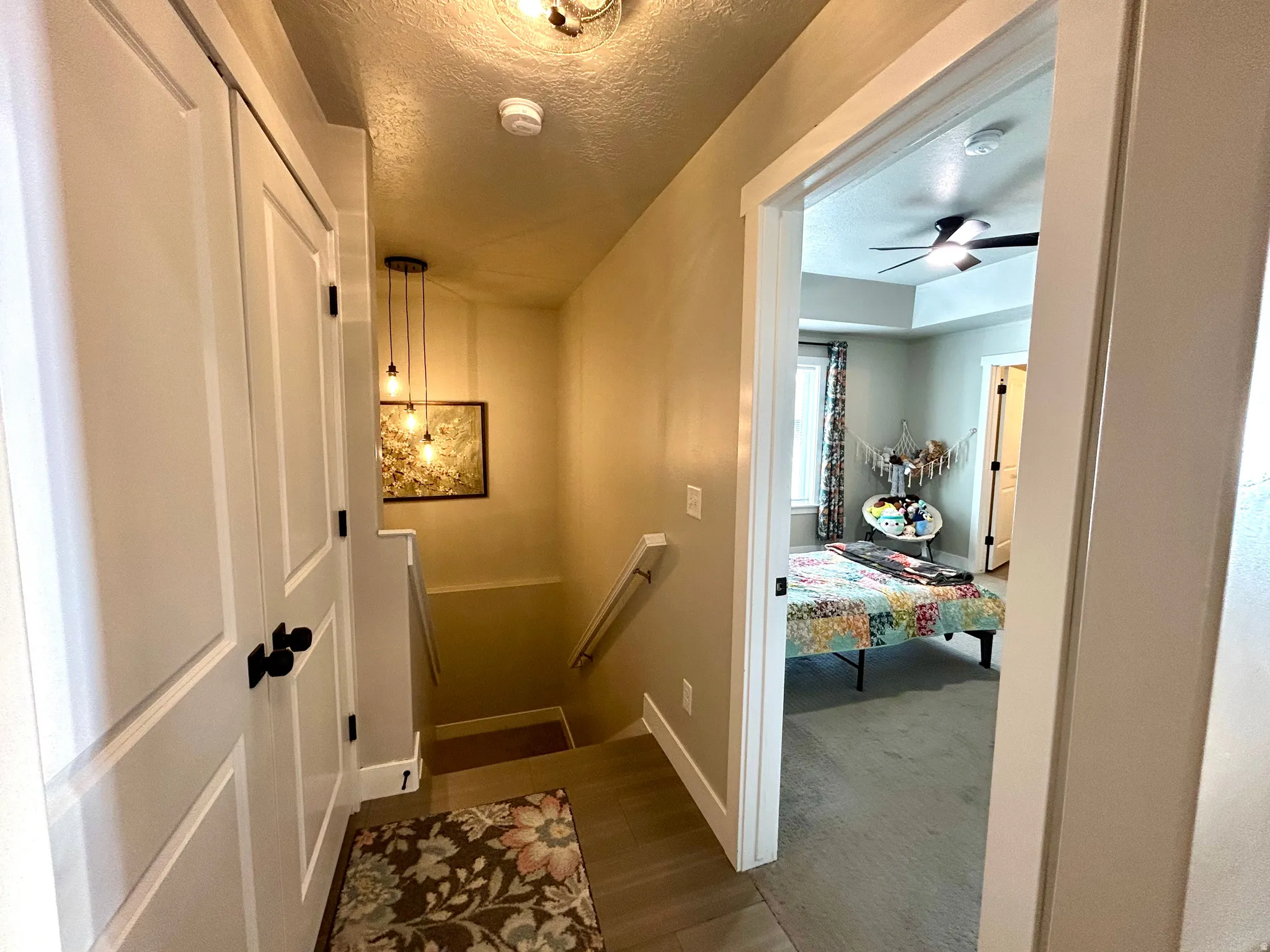 Hallway featuring wood-finish flooring and a contemporary multi-bulb pendant light