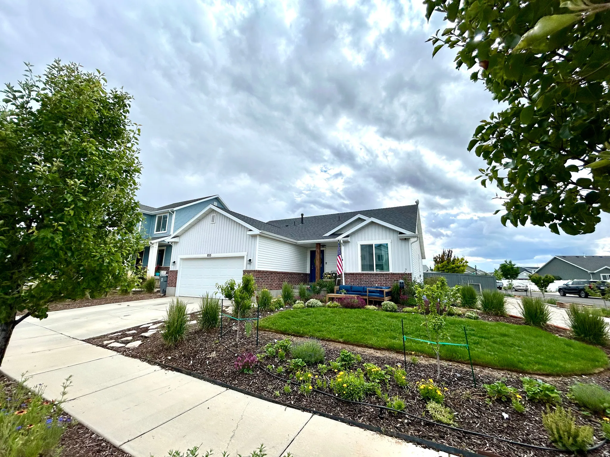 Contemporary home exterior featuring white siding and brick accents