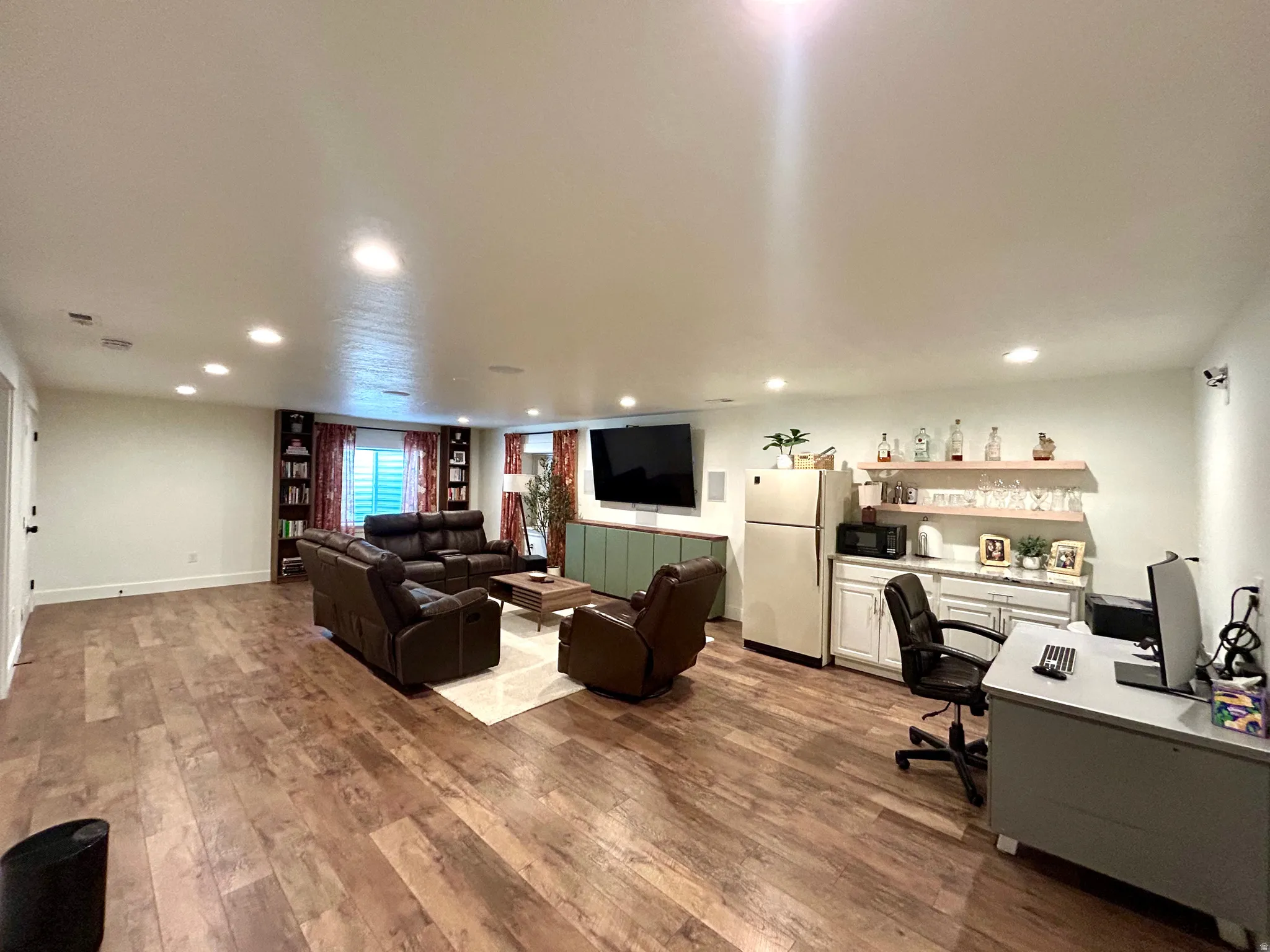 Spacious recreation room featuring wood-finish flooring and recessed lighting