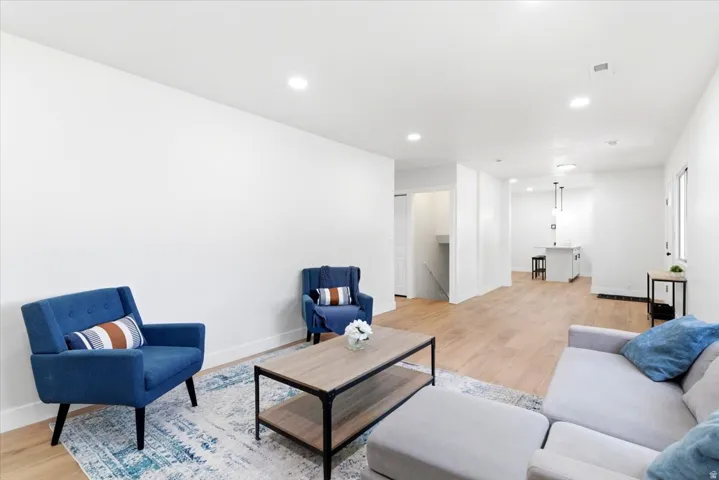 Open-concept living space featuring wood-finish flooring, recessed lighting, and white baseboards
