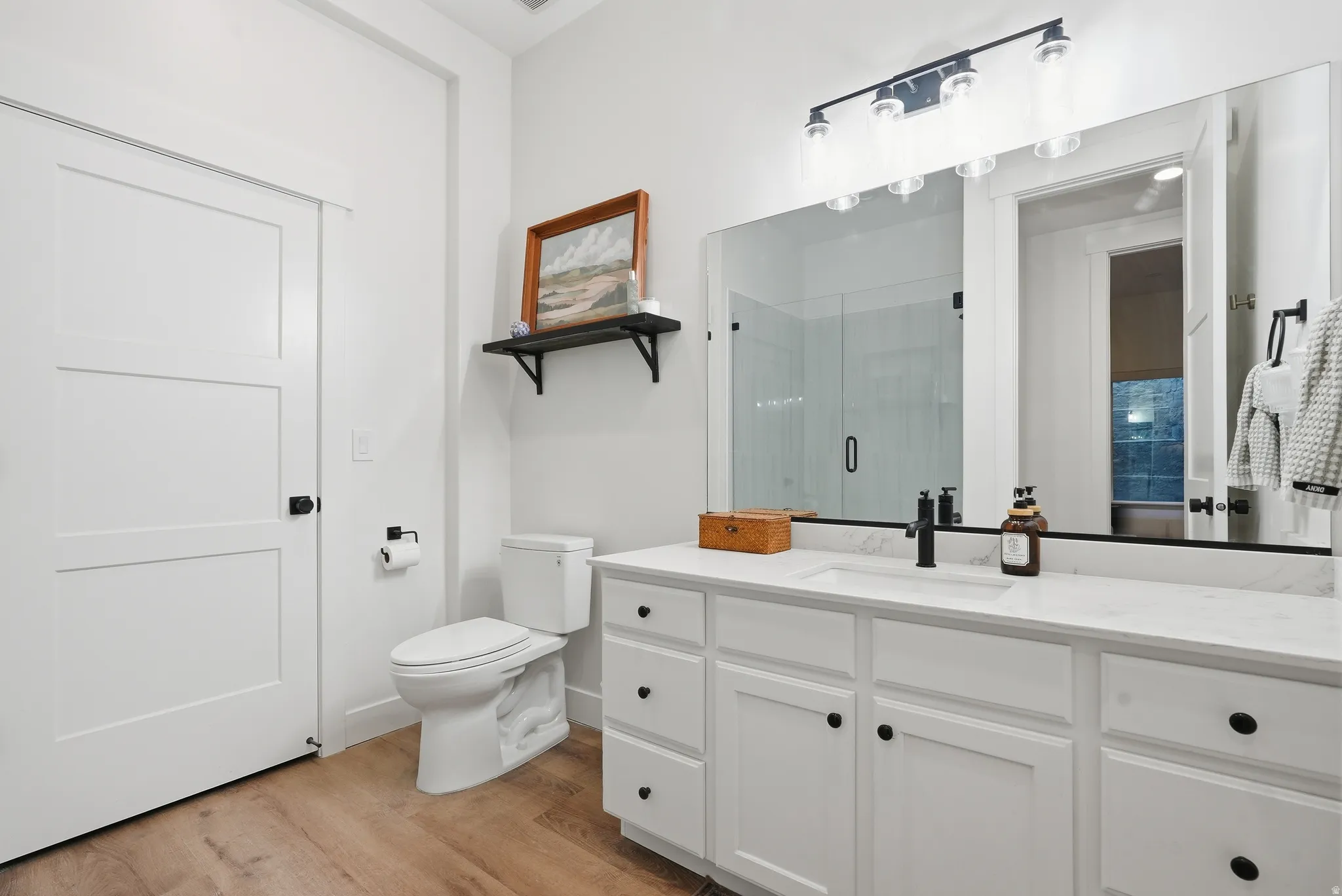 Bathroom featuring a white vanity with a white countertop, single undermount sink, and matte black faucet