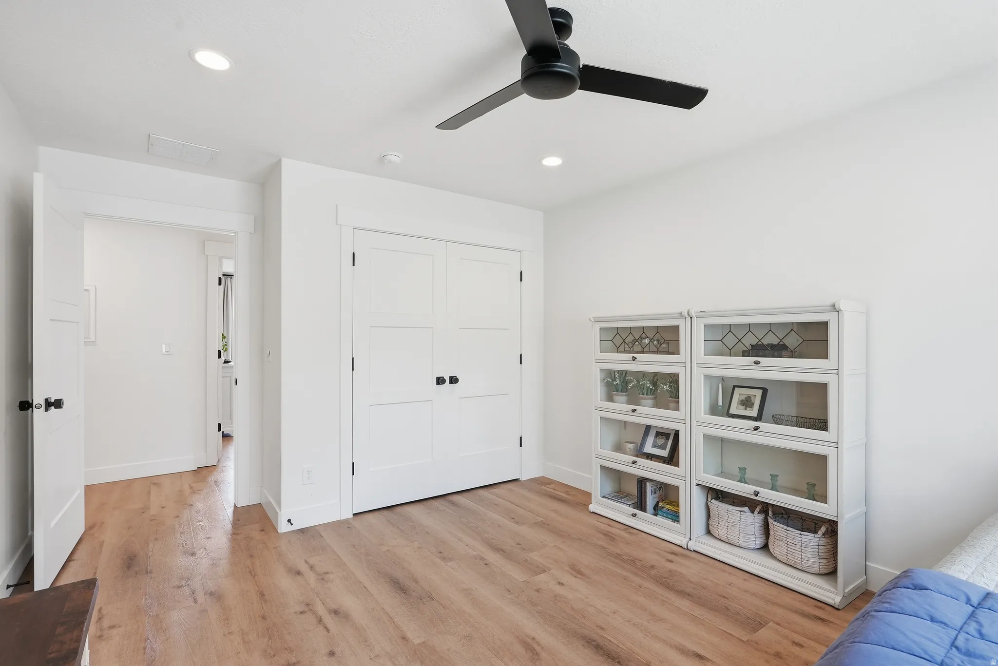 Bright interior space featuring LVP flooring, recessed lighting, a ceiling fan with matte black blades, and white trim