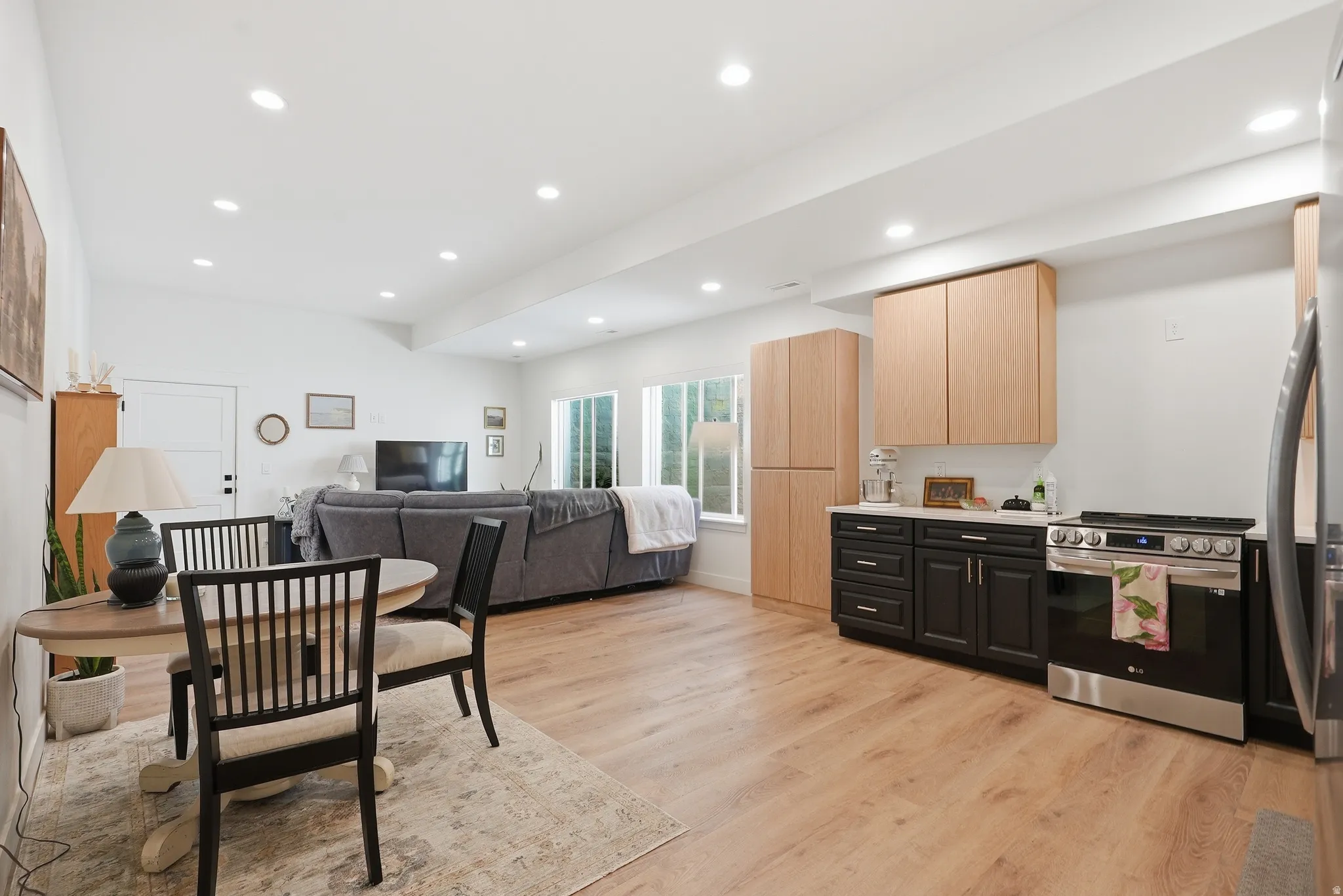 Open-concept living area featuring LVP flooring, recessed lighting, and white walls