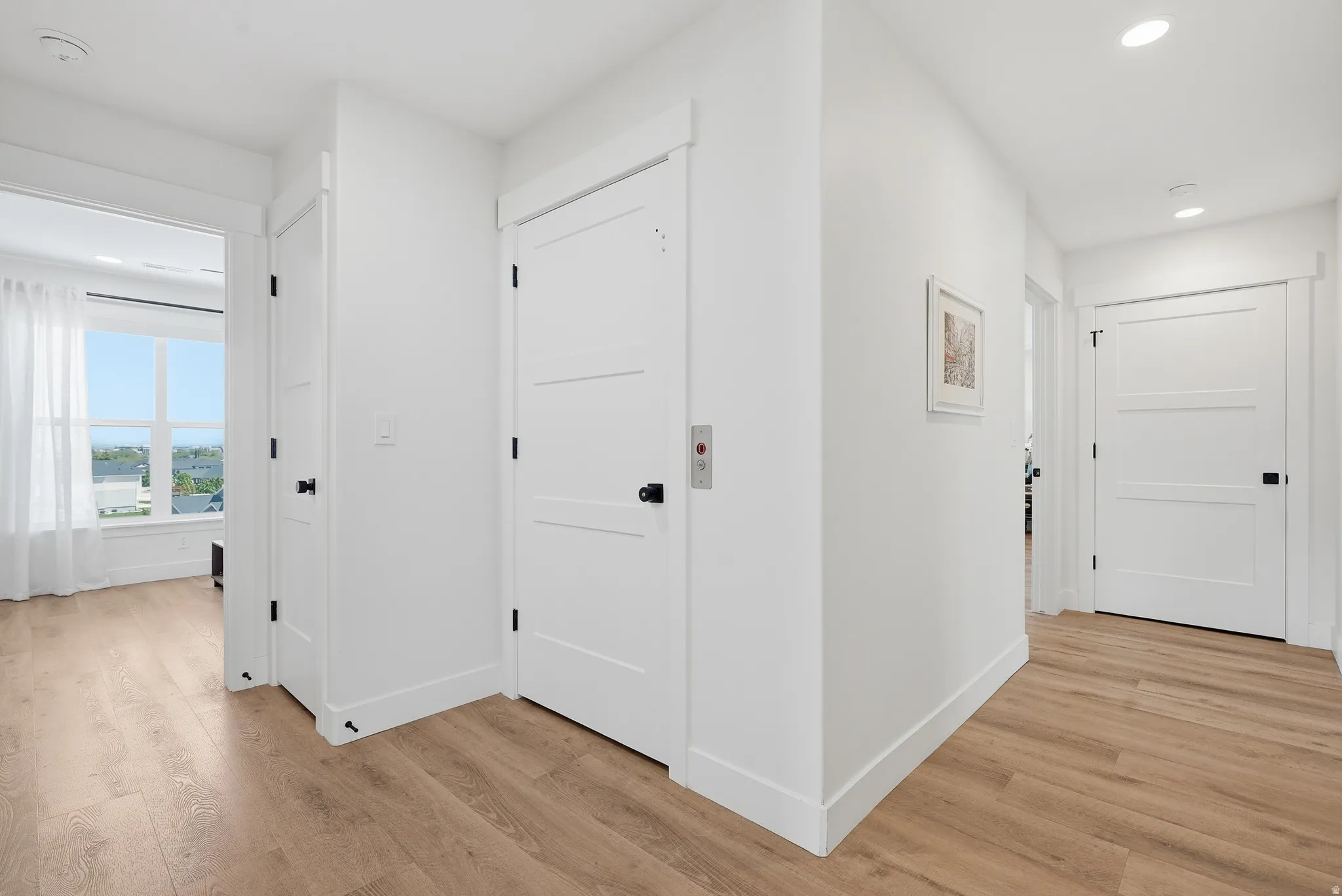 Hallway featuring LVP flooring, white walls, and recessed lighting