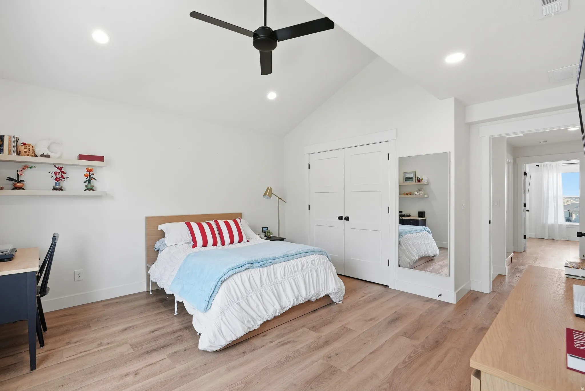 Vaulted ceilings complemented by recessed lighting and a black ceiling fan