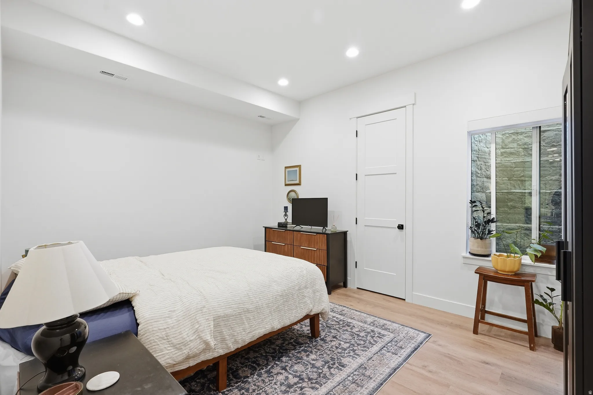Bright bedroom featuring LVP Flooring and recessed lighting
