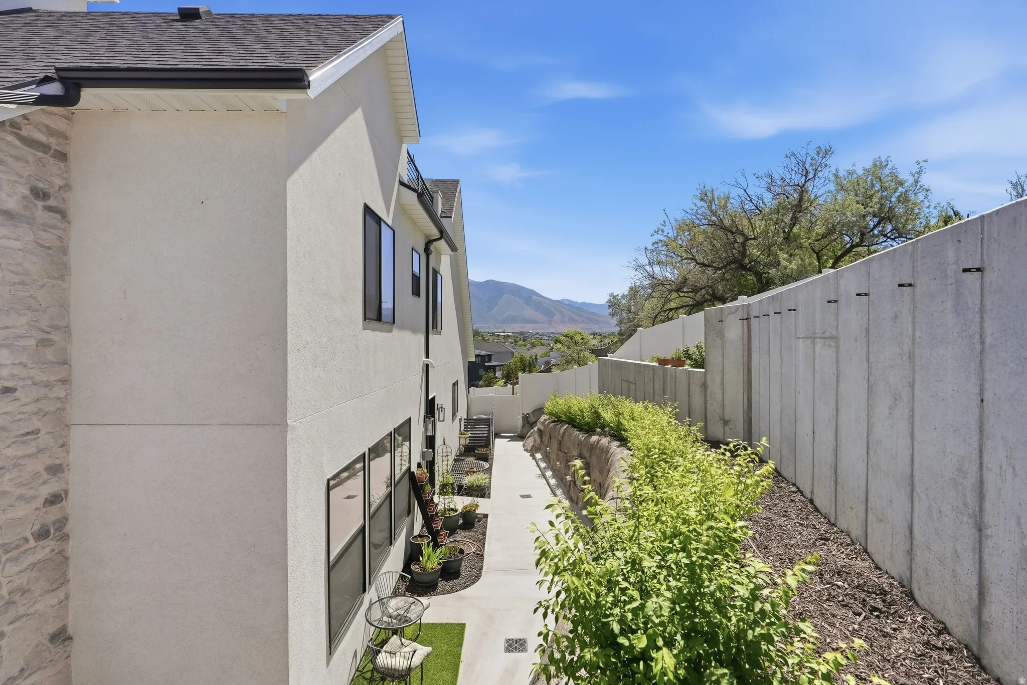 Stucco exterior with stone veneer accents and black-framed windows