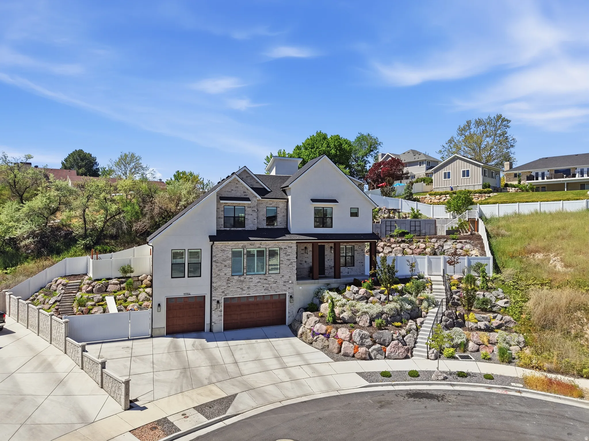 Residence featuring a three-car garage, a stone and stucco, and a covered entry porch