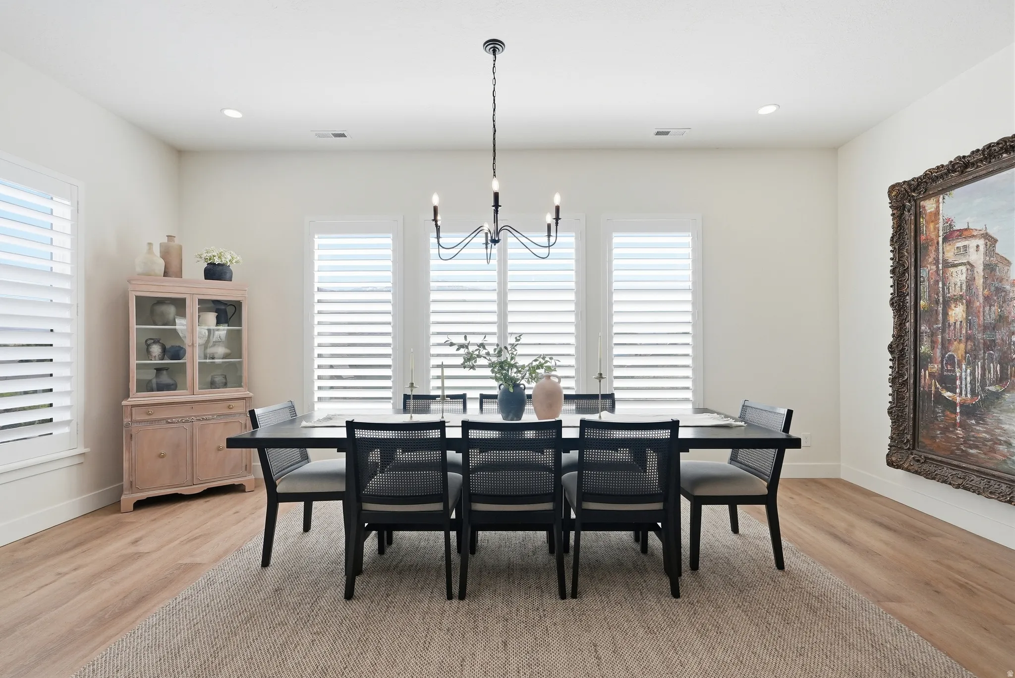 Dining area featuring LVP flooring, recessed lighting, and a modern chandelier