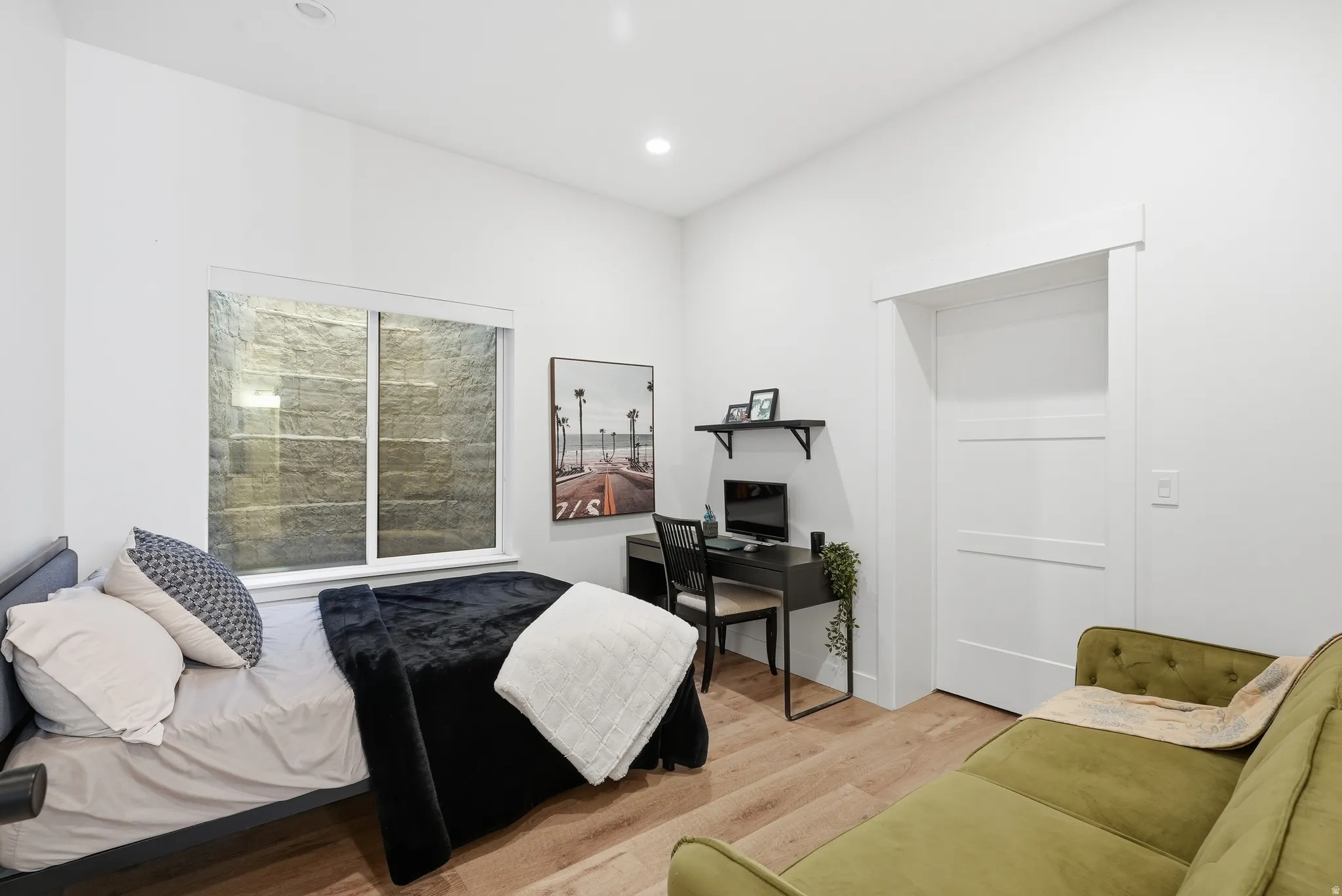 Bright interior space featuring recessed lighting, LVP finish flooring, a white window frame, and a white interior door with horizontal paneling