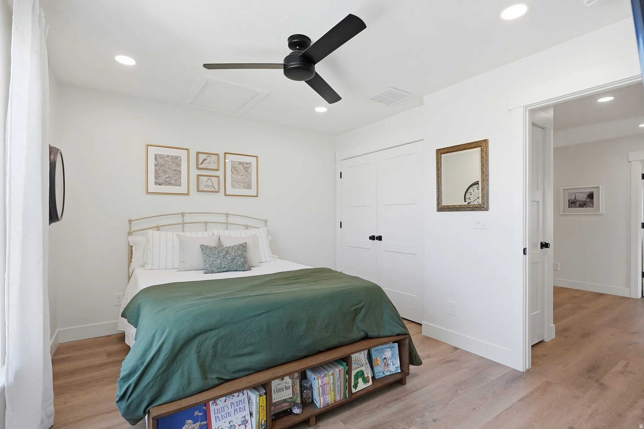 Light-toned LVP flooring provides a bright base for this room featuring a ceiling fan with black blades, recessed lighting, and white walls