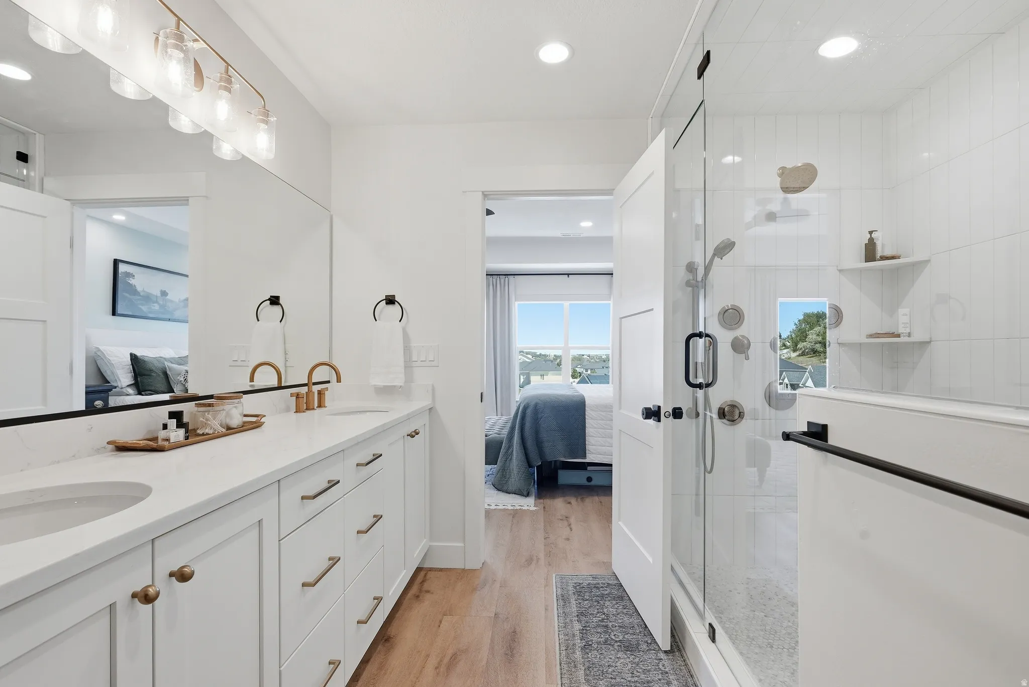 Bathroom featuring a double vanity with stone countertops, undermount sinks, and brushed gold fixtures