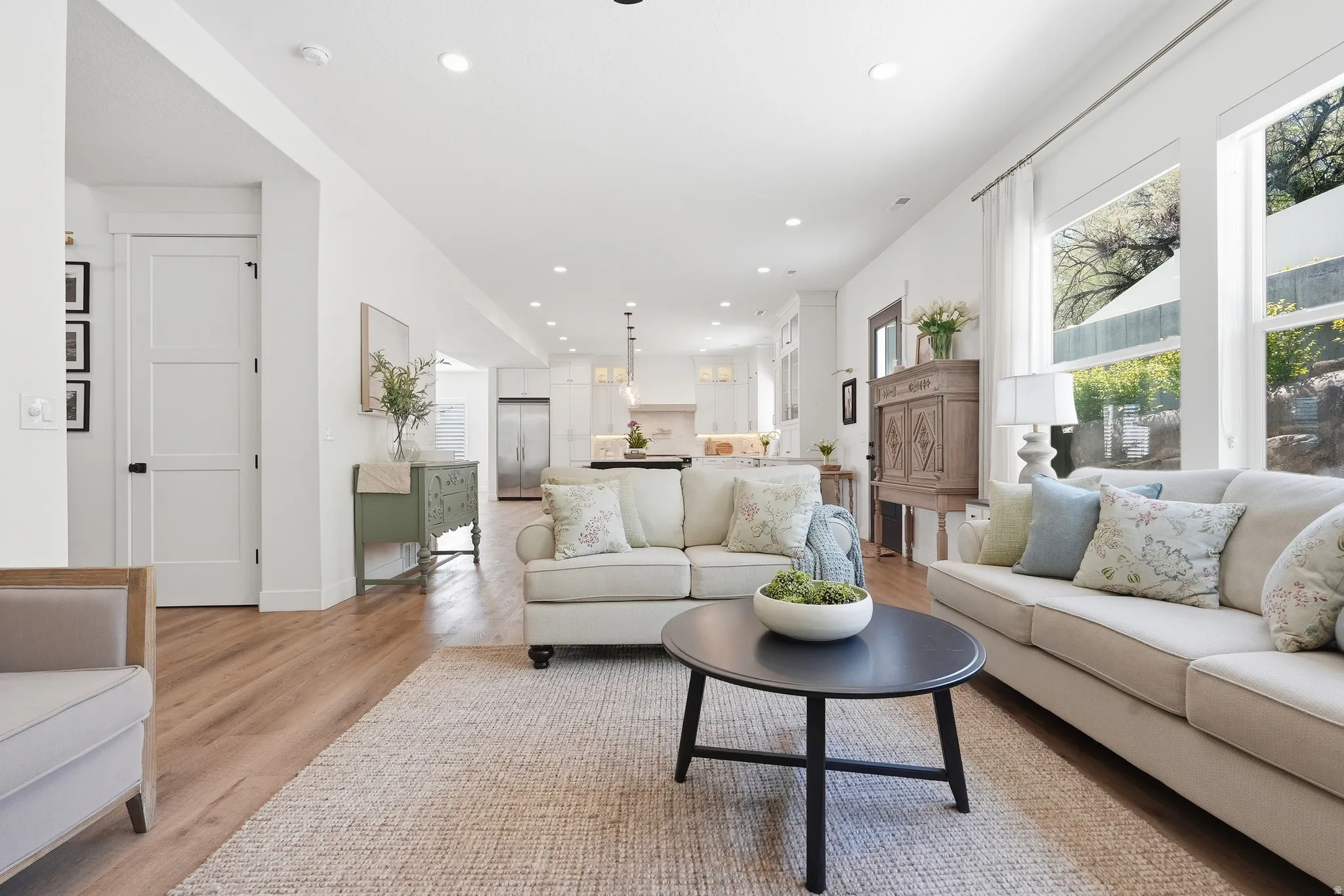Open-concept living area featuring LVP flooring, recessed lighting, and expansive windows