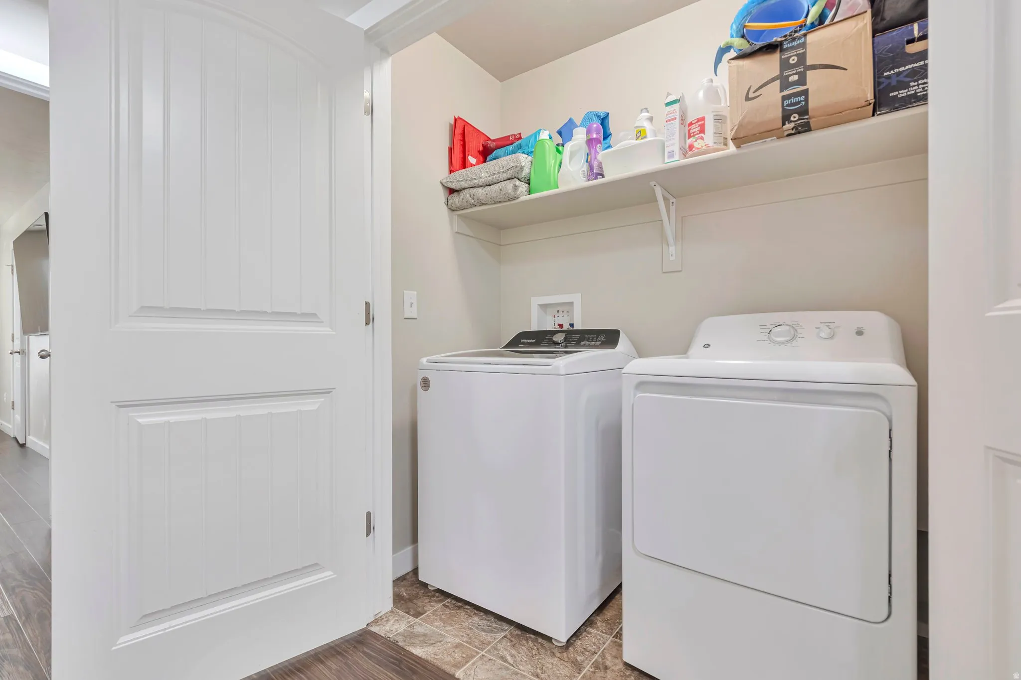Dedicated laundry space featuring a top-loading washing machine and front-loading dryer