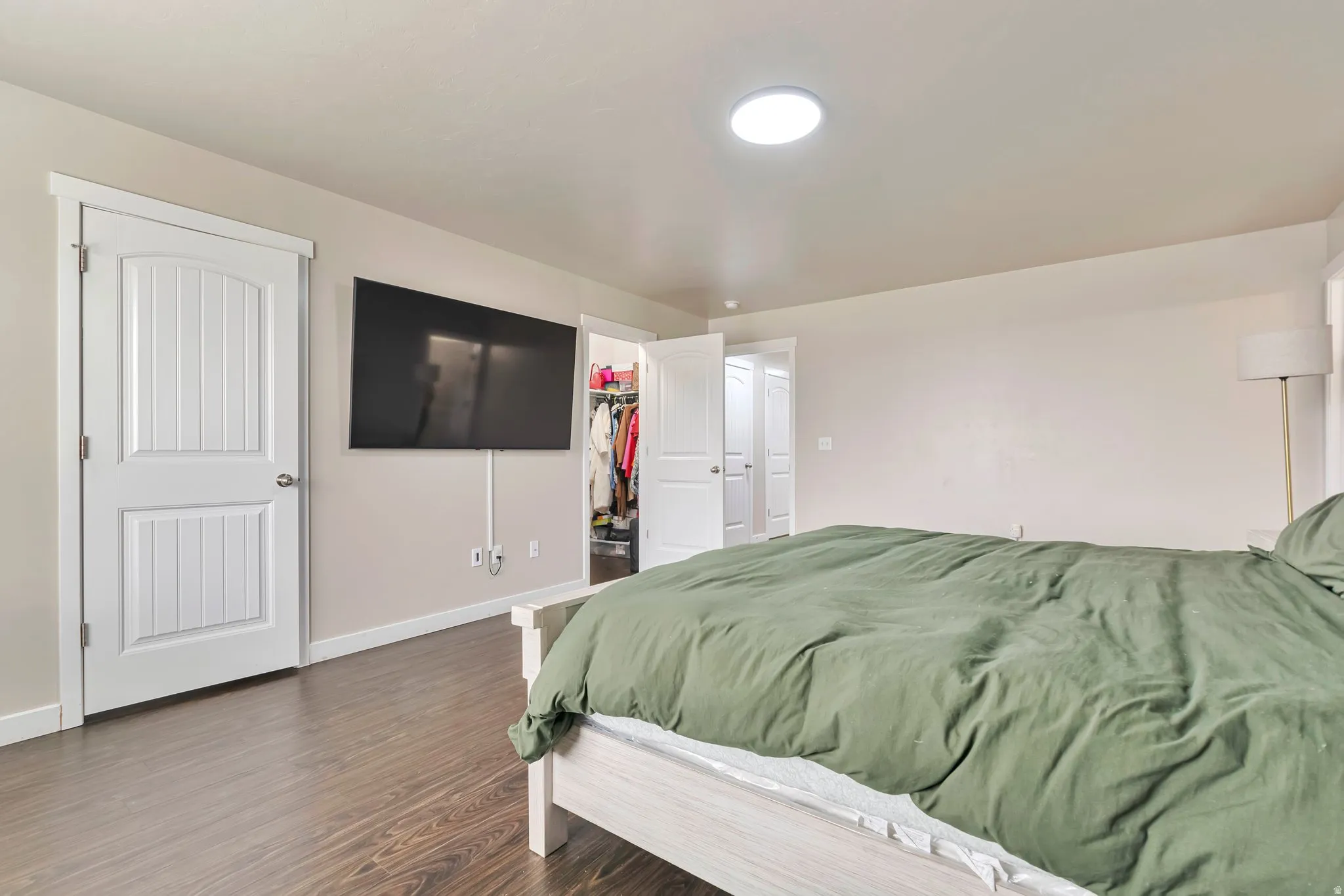 Room featuring wood-finish flooring, light-toned walls, and white trim