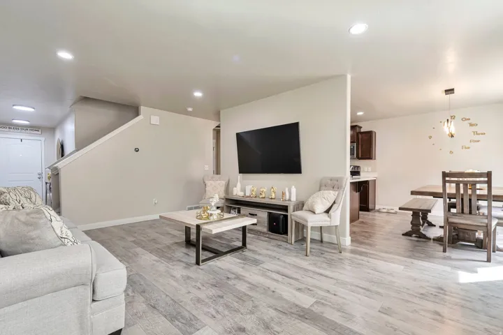Expansive main living area featuring wide-plank wood-finish flooring, recessed lighting, and a neutral color palette