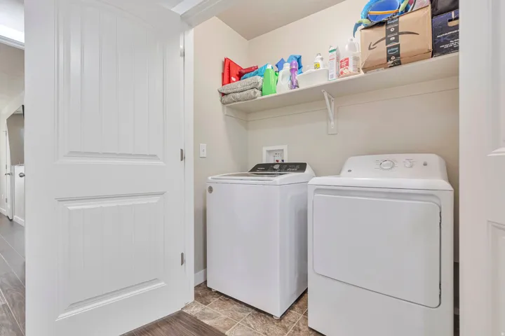 Dedicated laundry space featuring a top-loading washing machine and front-loading dryer