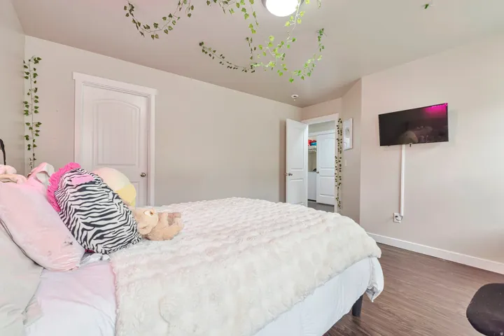 Spacious room featuring wood-finish flooring, light neutral wall tones, and a ceiling-mounted light fixture