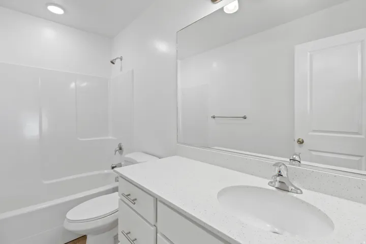 Modern bathroom featuring a white vanity with an integrated sink and light-toned countertop