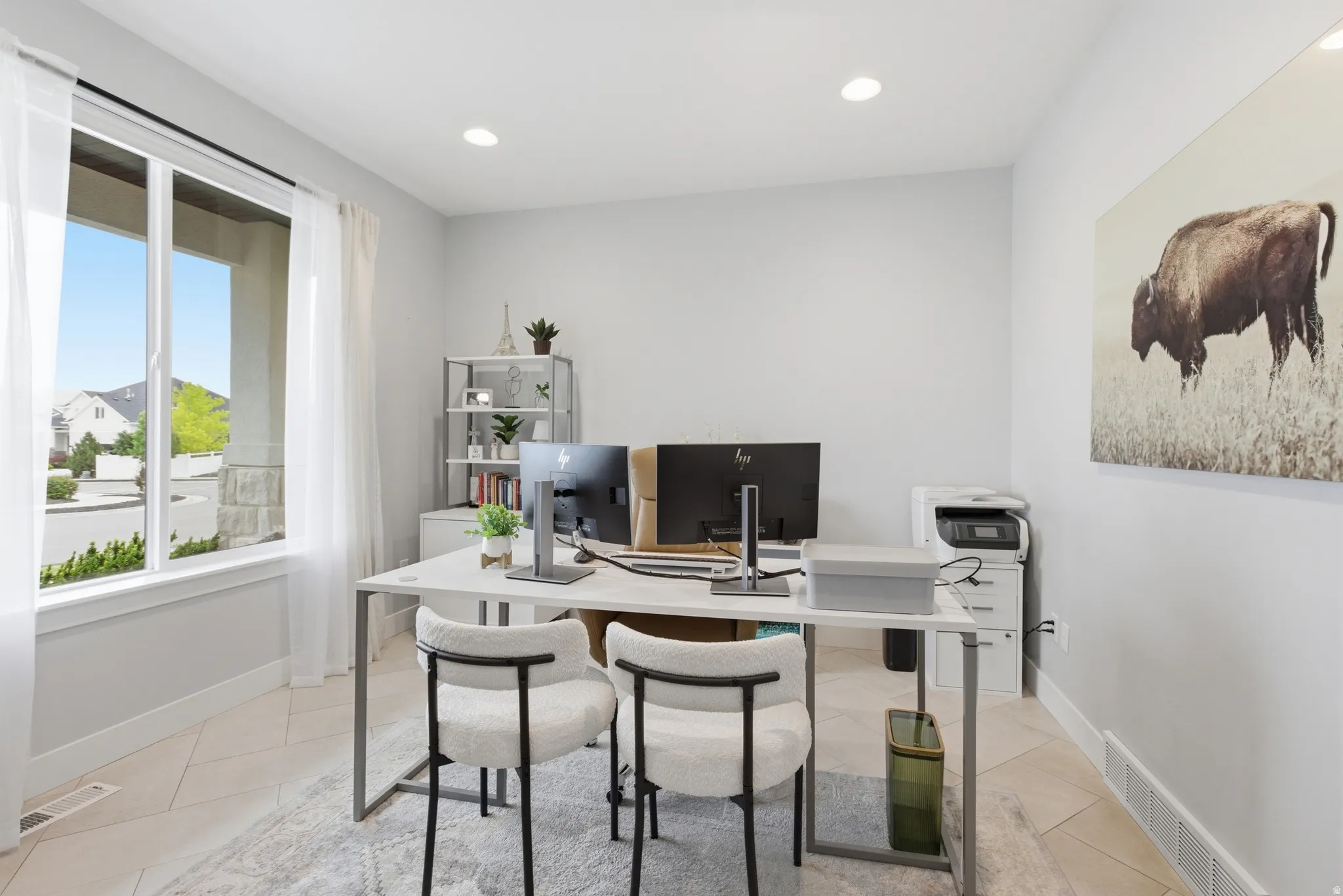 Bright room featuring a large window with sheer drapery, recessed lighting, and light-toned flooring