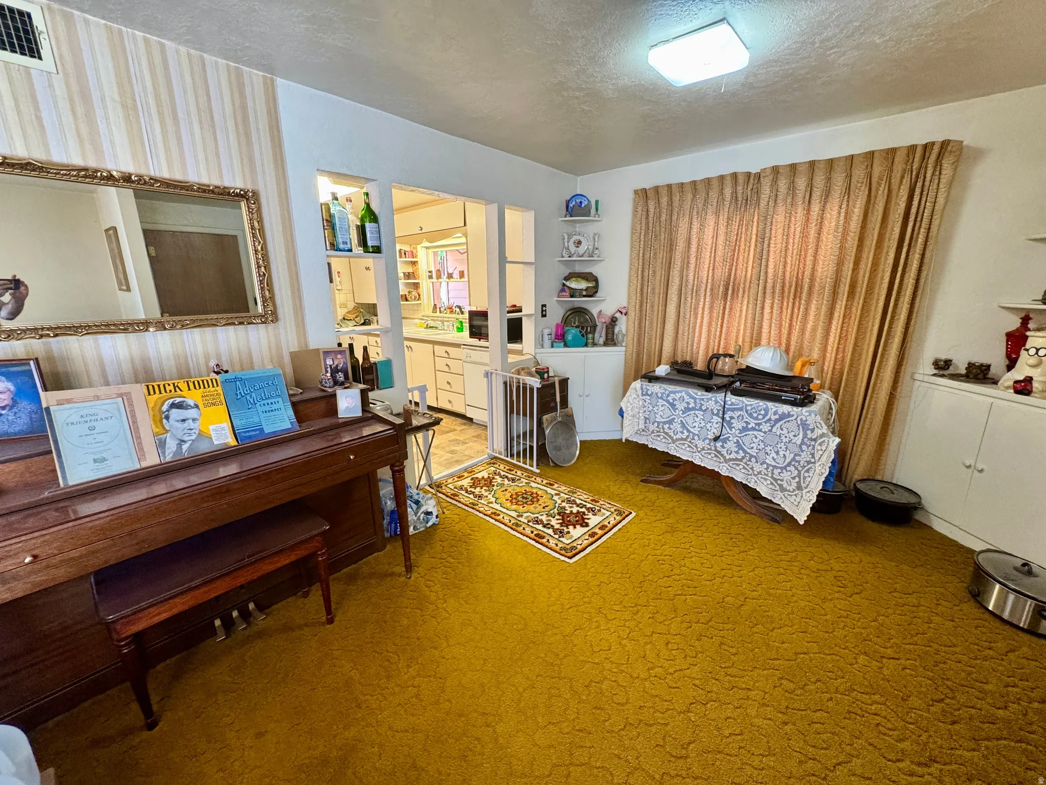 Interior room featuring a gold-toned textured carpet and striped wallpaper accents