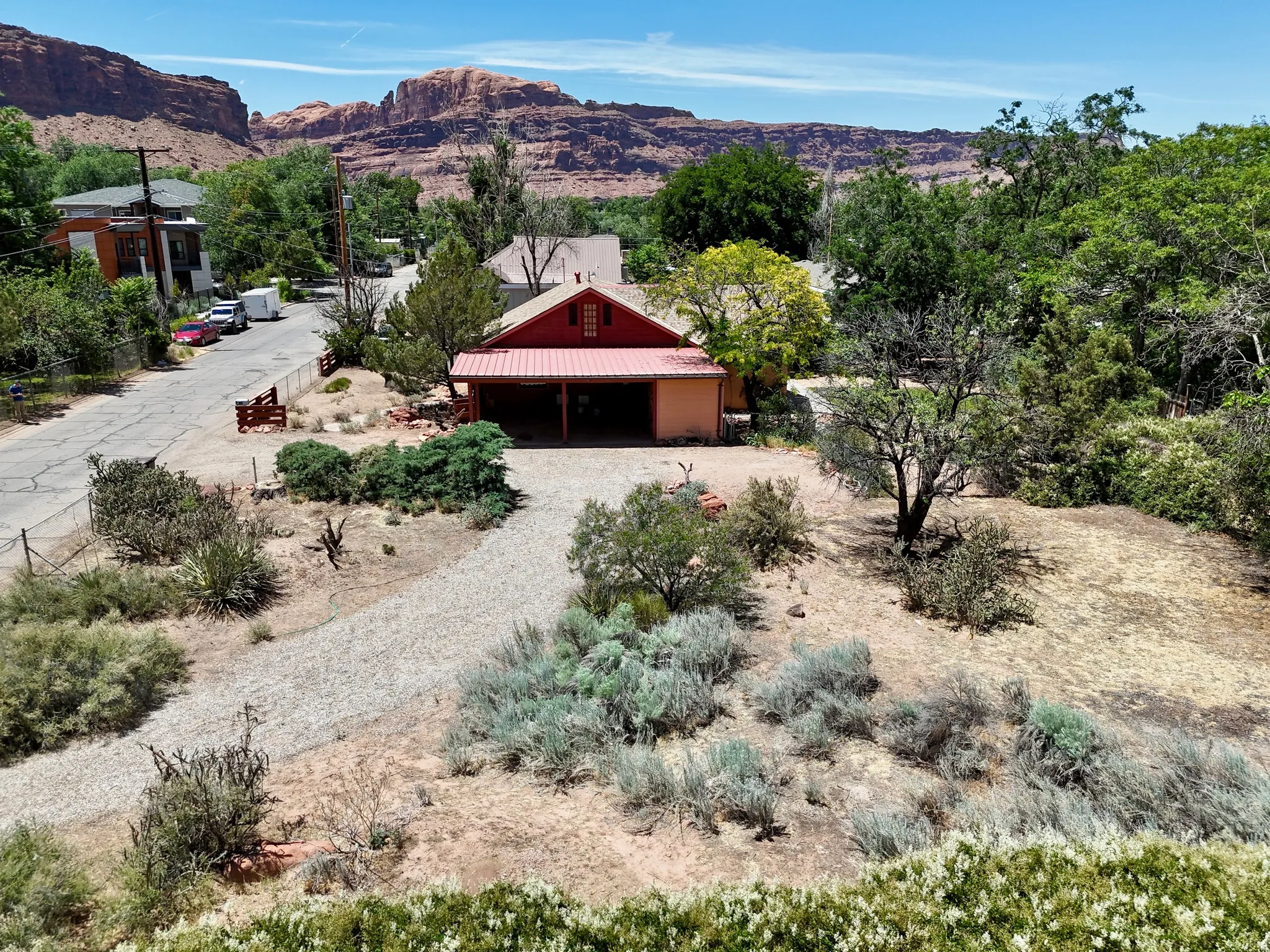 Red-sided structure featuring a covered porch with a metal roof