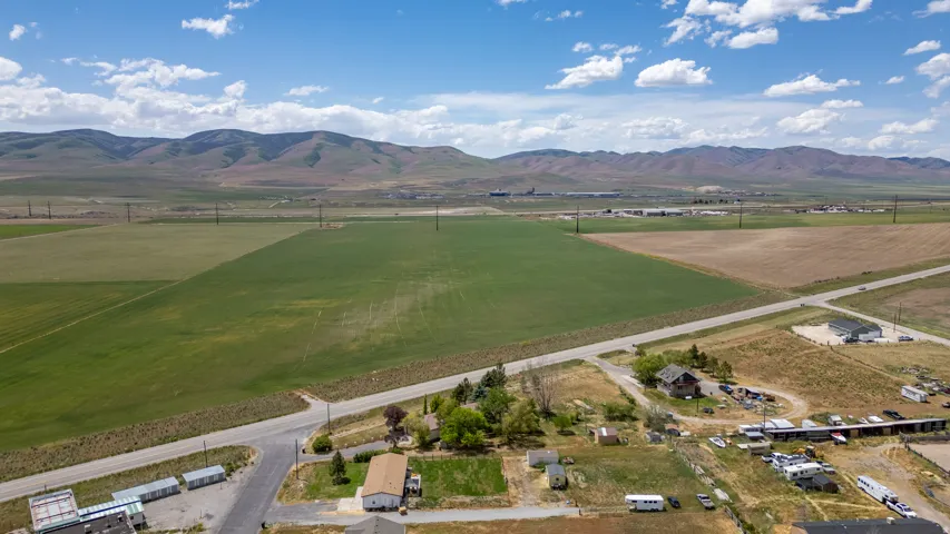 Expansive agricultural land featuring a verdant field and distant mountain range