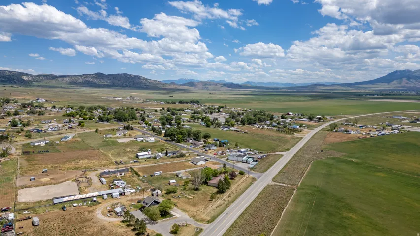 Expansive landscape featuring distant mountains, a wide-open plain, and a rural community with scattered residences