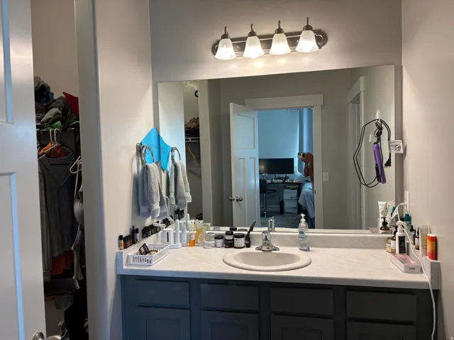Vanity with an integrated sink, a light-toned countertop, and dark cabinetry