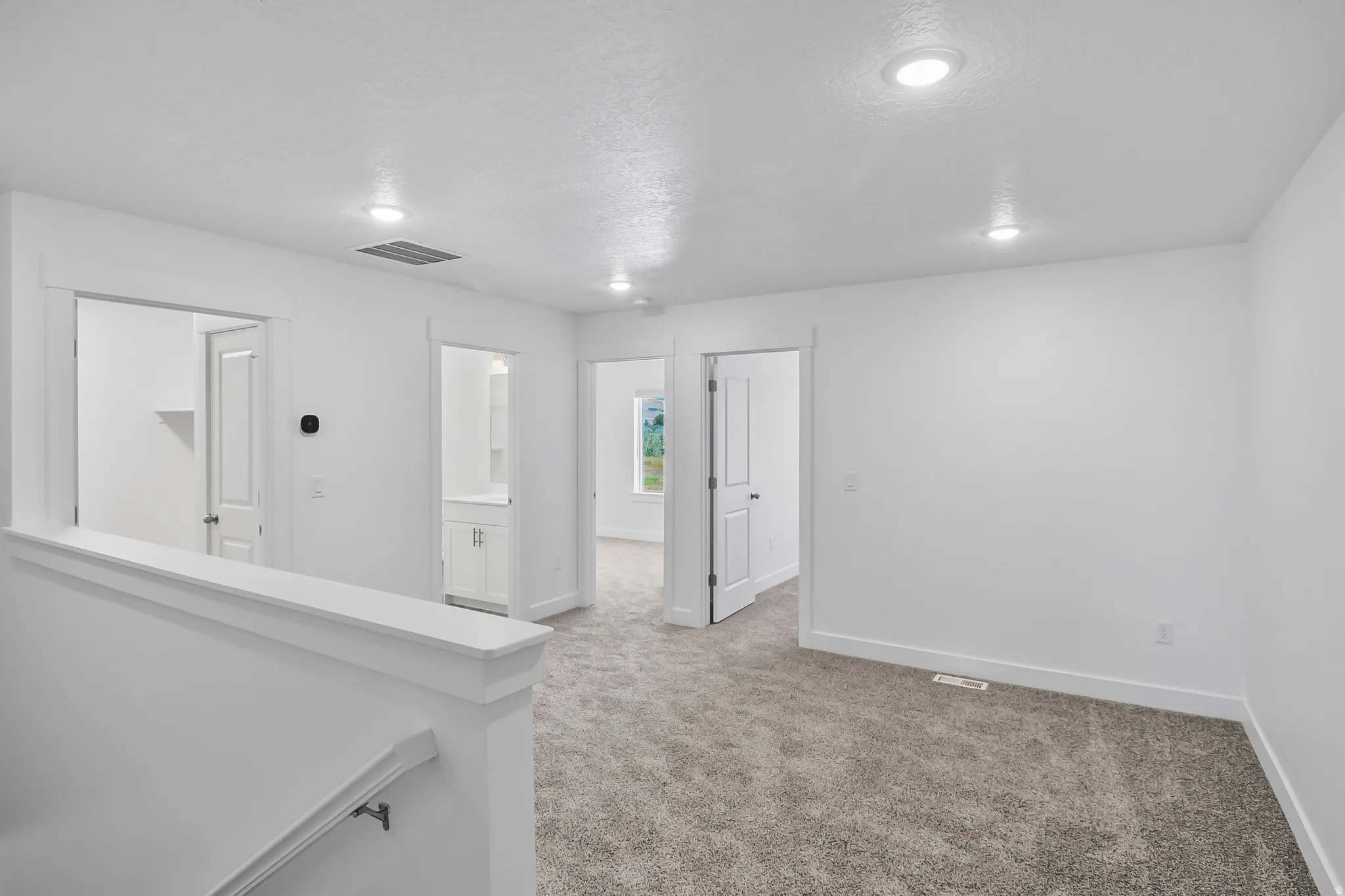 Carpeted landing area featuring recessed lighting, white walls, white trim, and white doors