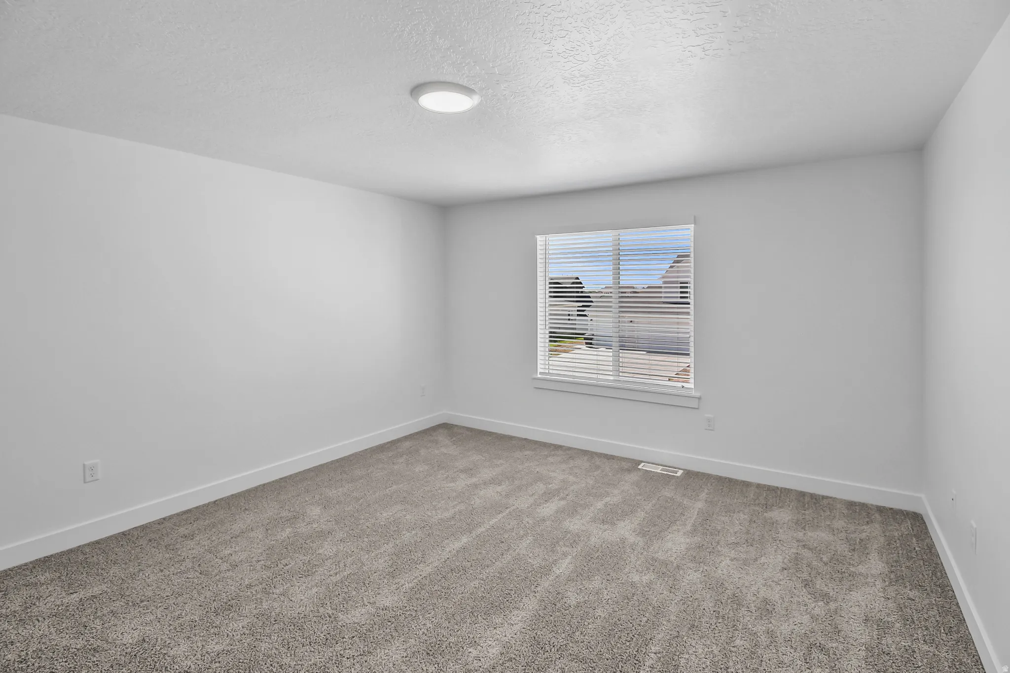 Bedroom featuring neutral grey carpeting and white walls