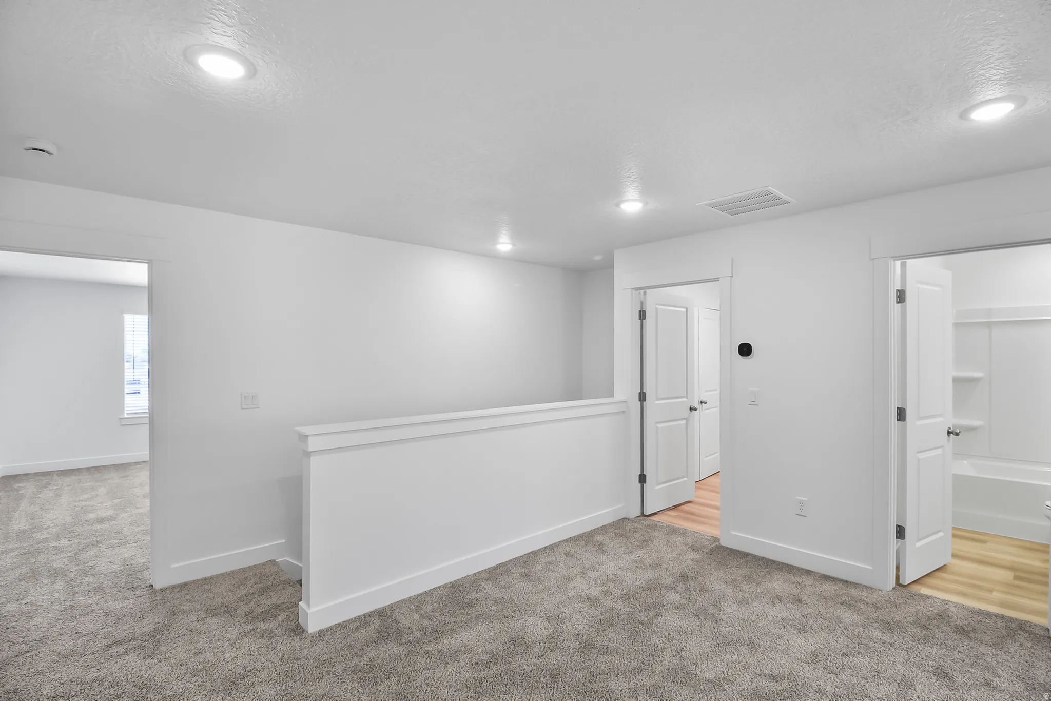 Carpeted loft area featuring recessed lighting