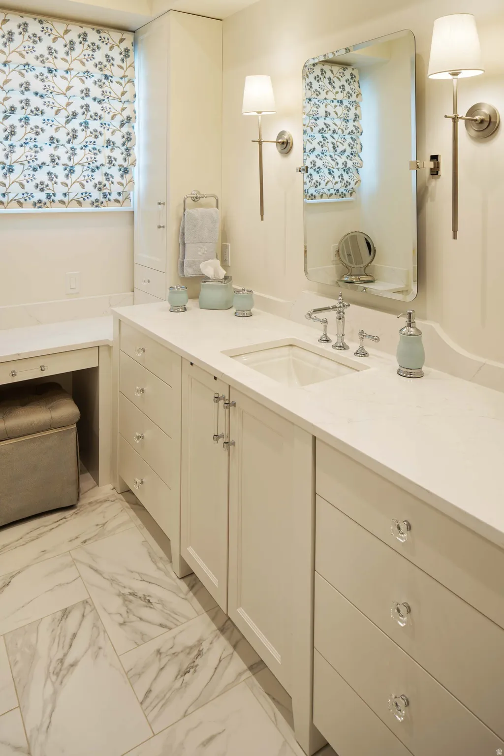 Bathroom featuring a single vanity with an integrated sink, polished chrome faucet, and a large wall-mounted mirror