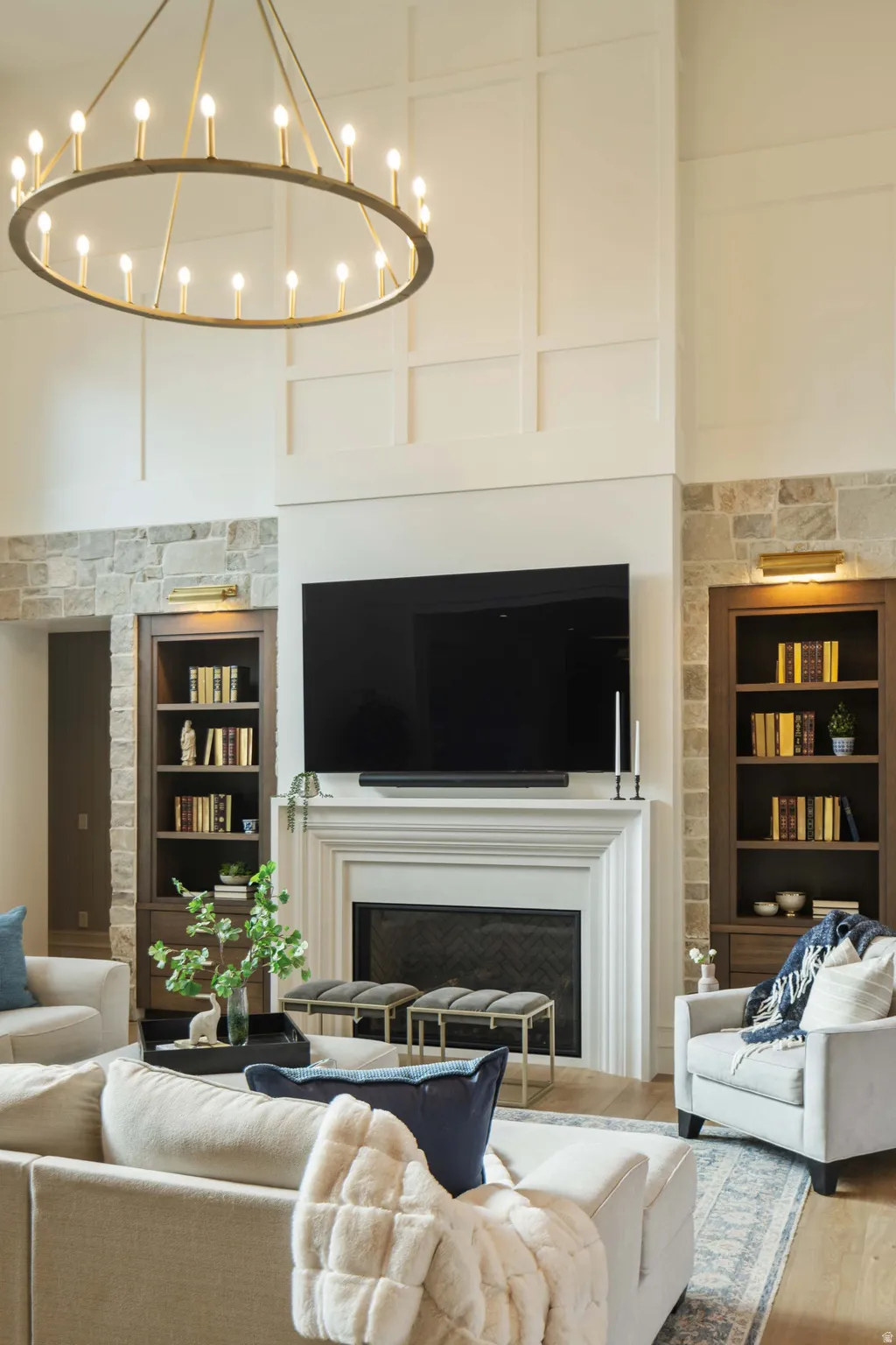 Spacious living area featuring a central fireplace with an ornate mantel, flanked by built-in wood-finish bookshelves