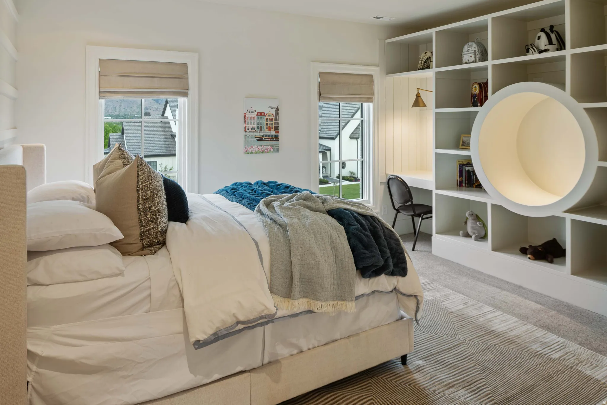 Integrated shelving unit with built-in desk, accent lighting, and a unique circular recess
